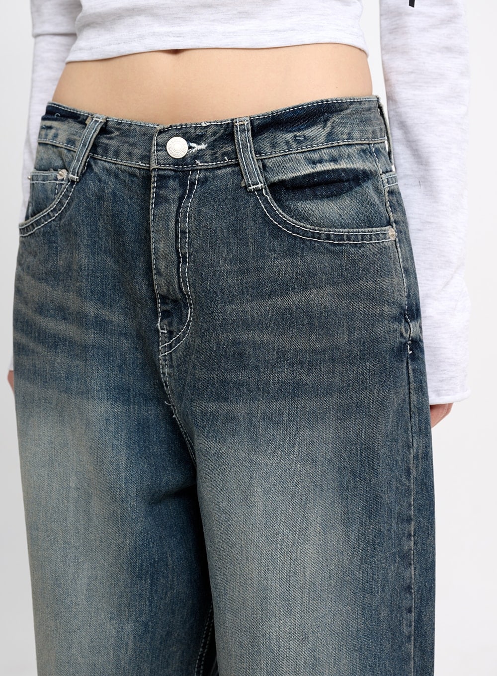 Low Waist Baggy Jeans CM415 in dark blue, waistband close-up on model, highlighting low-rise fit, silver button, contrast topstitching, and vintage-wash front pockets.