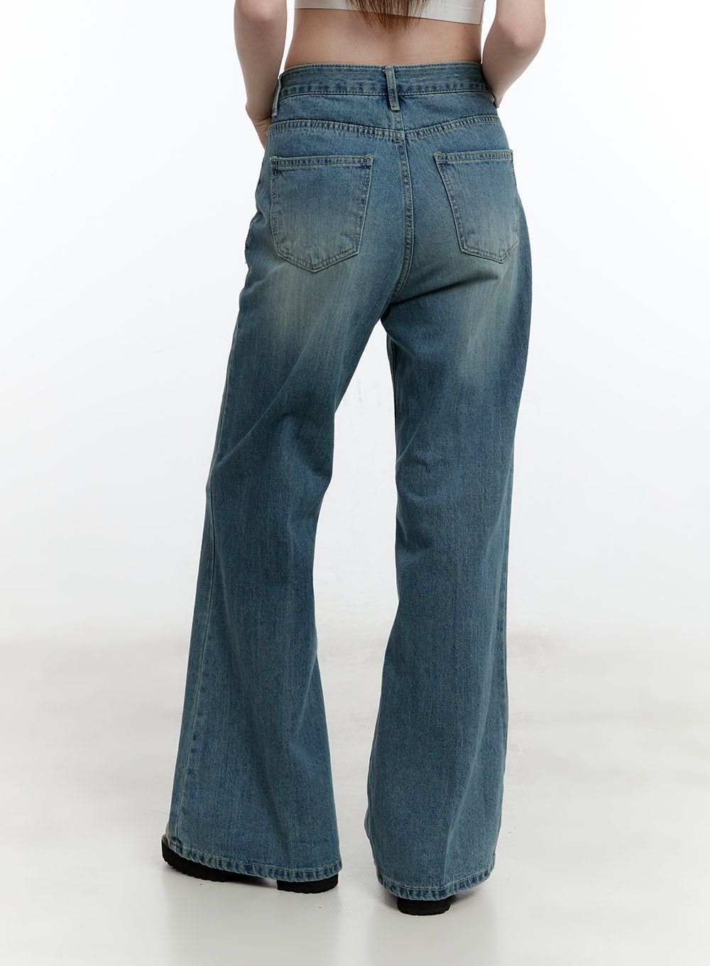 Aleks Relaxed-Fit Flared Jeans CM521 in blue, back view on model, rear patch pockets with stitching detail, washed cotton denim, flared bootcut hem visible from behind.