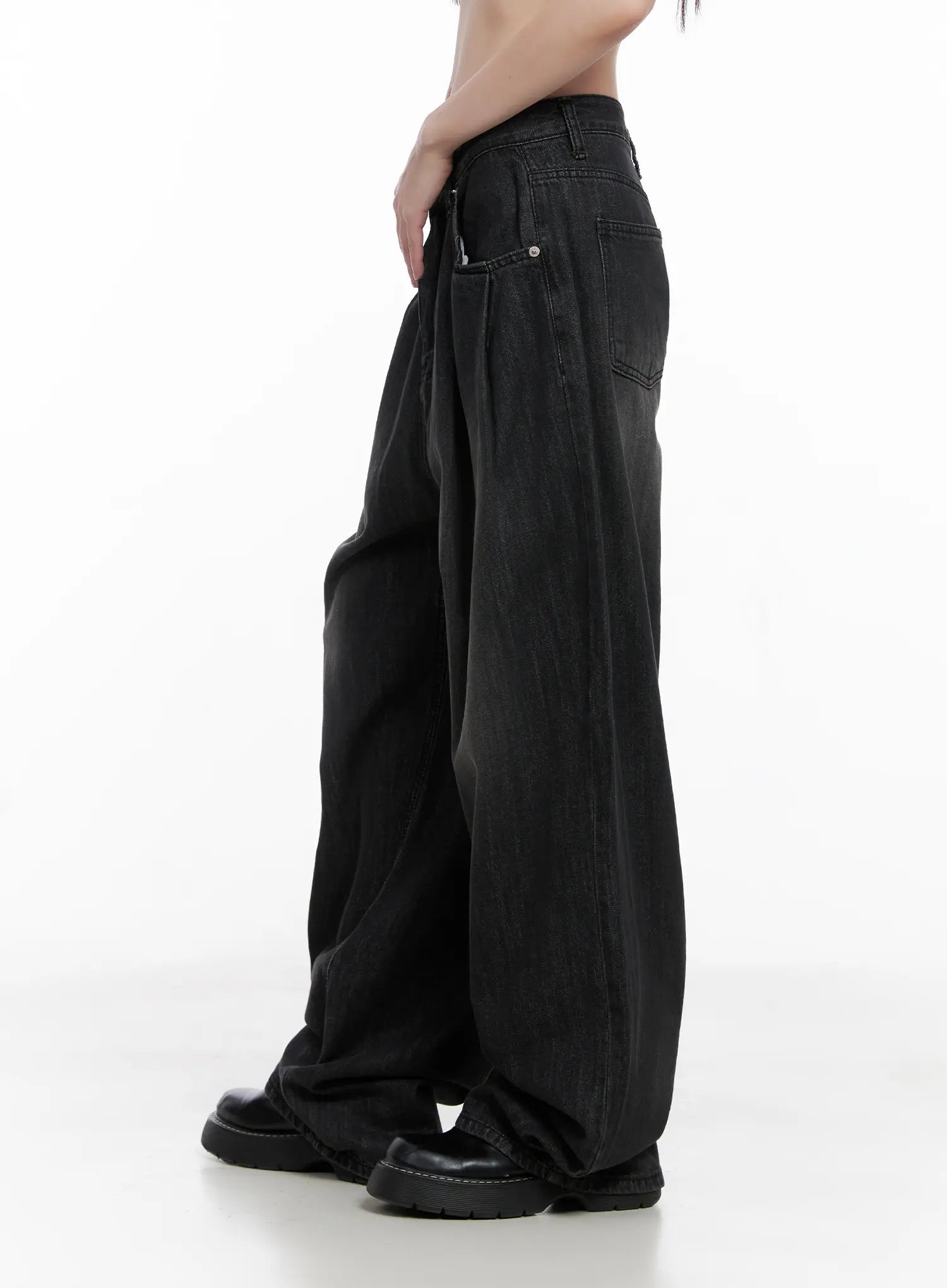 Elen Pintuck Baggy Jeans CG519 in black, side view on model, cropped torso, highlighting oversize wide-leg fit, washed denim drape, and back pocket, with black leather boots.