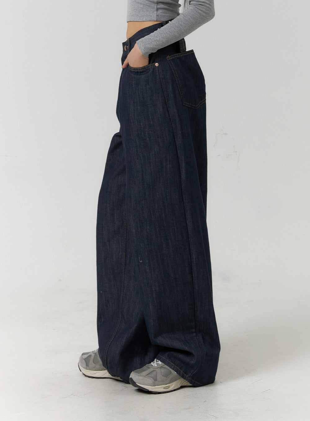 Back Button Wide Leg Jeans CF407 in blue, close side view on model, dark indigo denim showing extreme wide-leg volume and seam detail, hand in pocket.