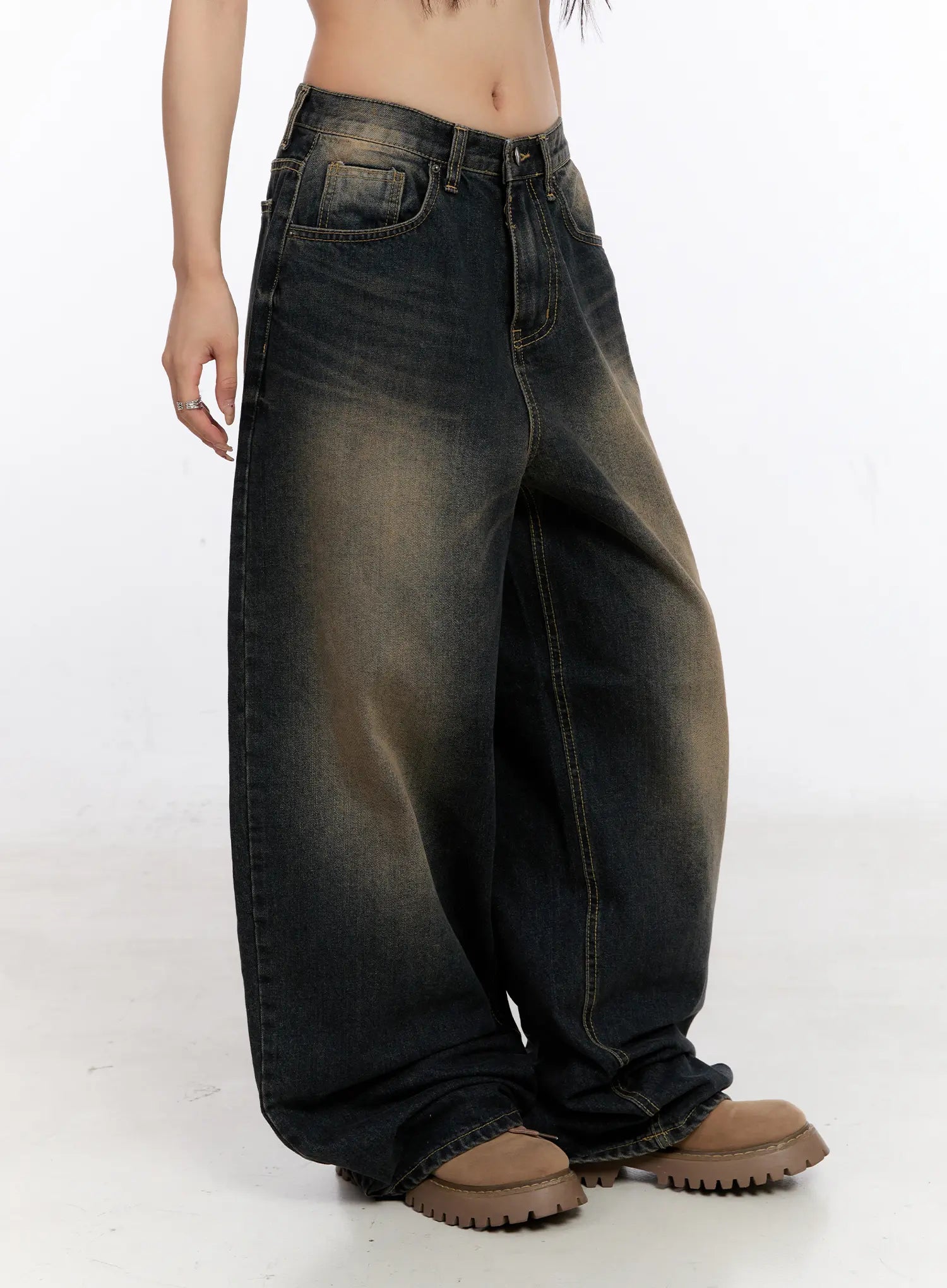 Sylvia Vintage Washed Baggy Jeans CO501 in dark blue, side view on model, highlighting extreme wide-leg silhouette, amber fade wash, contrast stitching, and pooled hem over chunky loafers.