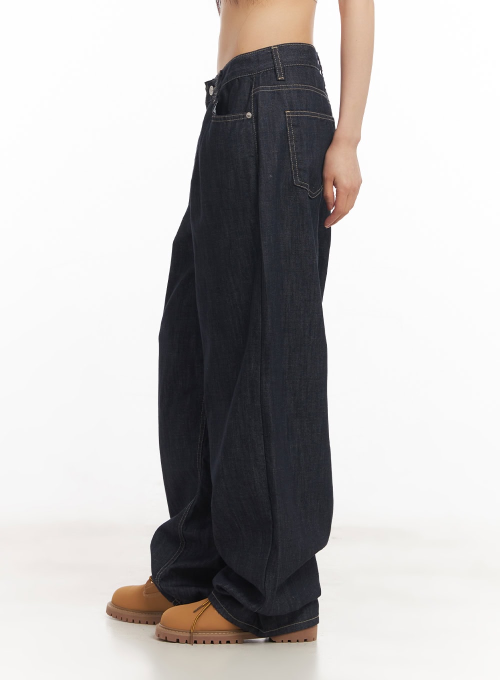 Ivara Wide-Leg Jeans CA522 in dark blue, three-quarter side view on model, clean low-rise waist with tonal V-stitch pocket detail and voluminous wide-leg cotton denim leg.