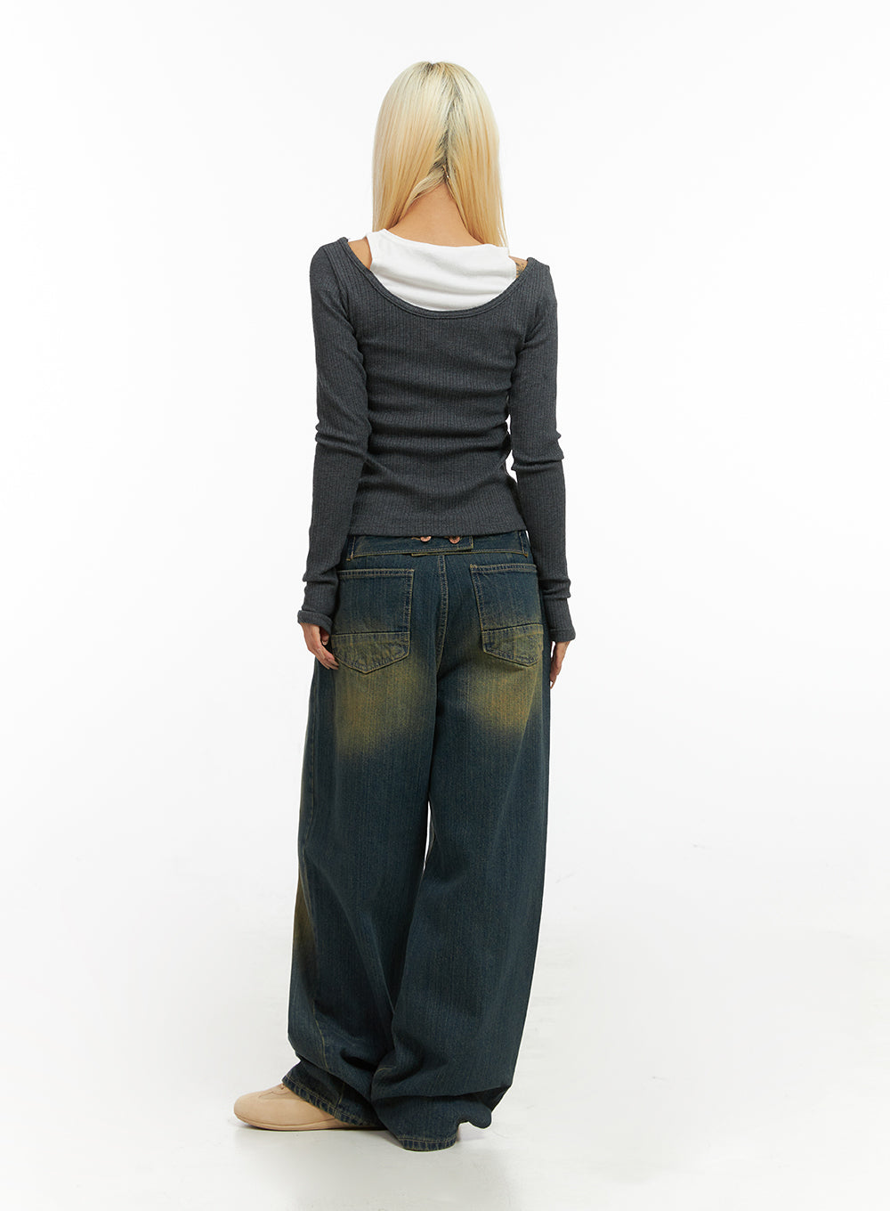 Georgia Vintage Wash Baggy Denim Jeans CO414 in dark blue, back full-body shot on model, large patch back pockets with yellow wash detail, paired with grey ribbed layered top, beige shoes.