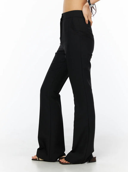 Basic High-Waist Stretch Flared Slacks CU522 in black, close-up side view on model, high-waist banded waistband, front center crease, flared silhouette from knee to hem, worn with strappy sandals.