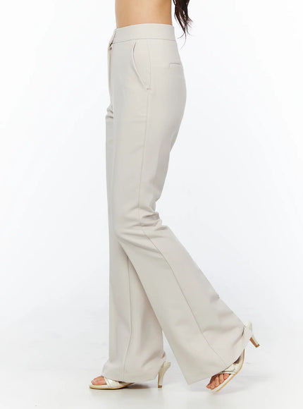 High-Waist Stretch Flared Slacks CU522 in light beige, side close-up on model, showing high waistband, zip fly, slim hip with gradual flare, center-front seam detail.