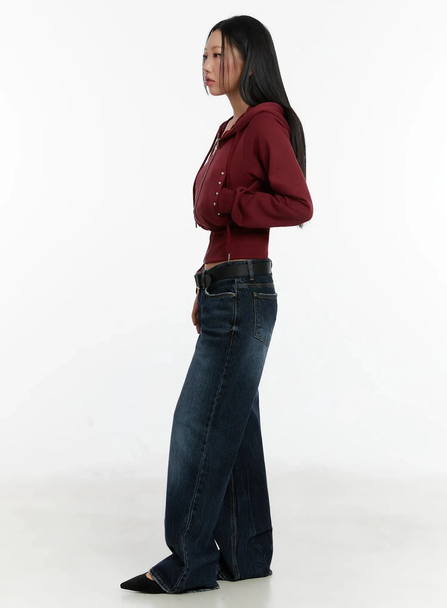 Aimee Low Rise Wide Leg Jeans ID525 in dark blue wash, side profile on model, low-rise waistband and long wide leg with washed cotton fabric, styled with burgundy zip hoodie and black belt.
