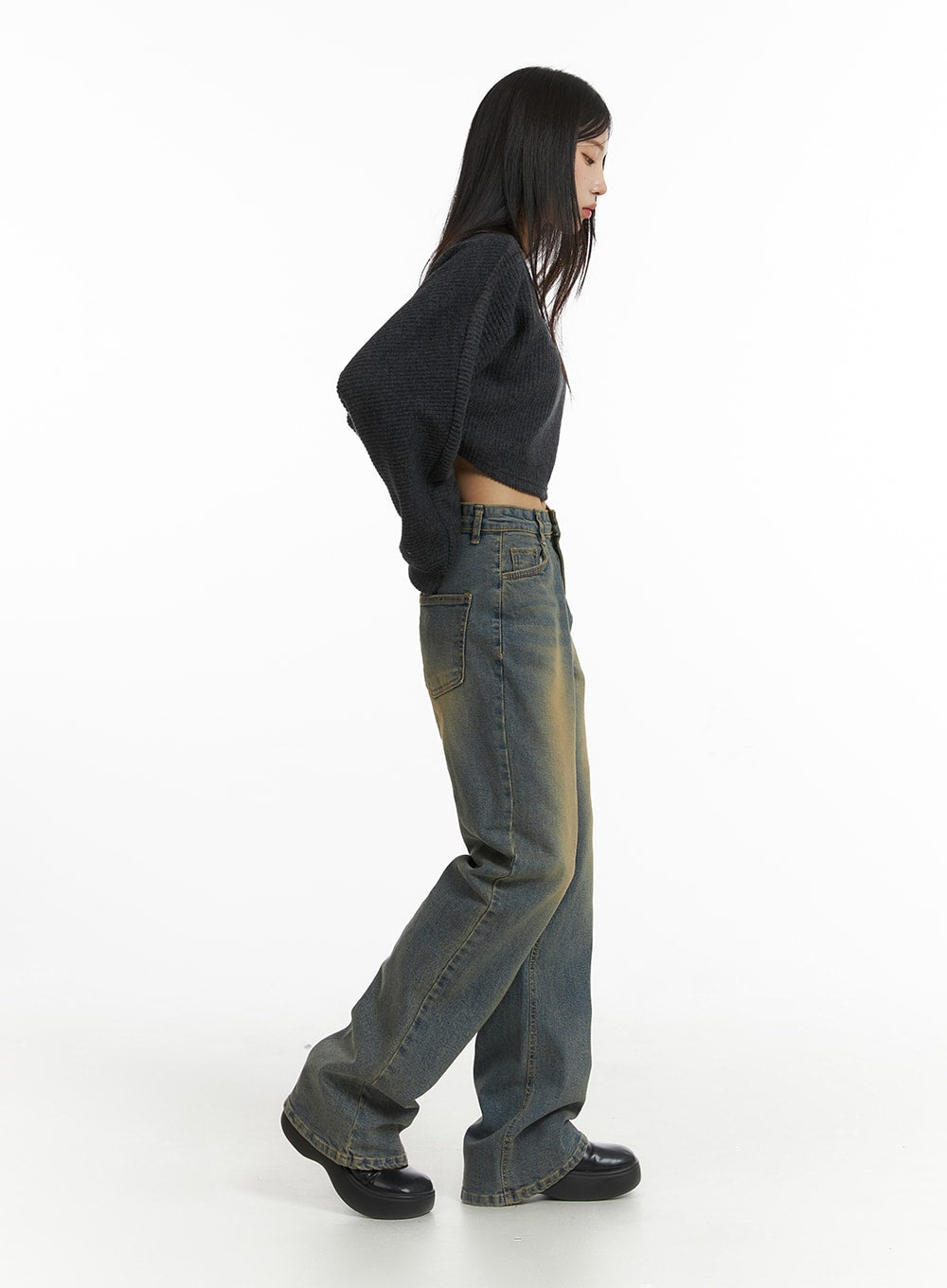 Washed Slim Fit Bootcut Jeans CJ431 in blue, side view on model, grey crop knit sweater on top, showcasing slim thigh fit tapering into subtle bootcut flare, vintage yellow wash on side seam.