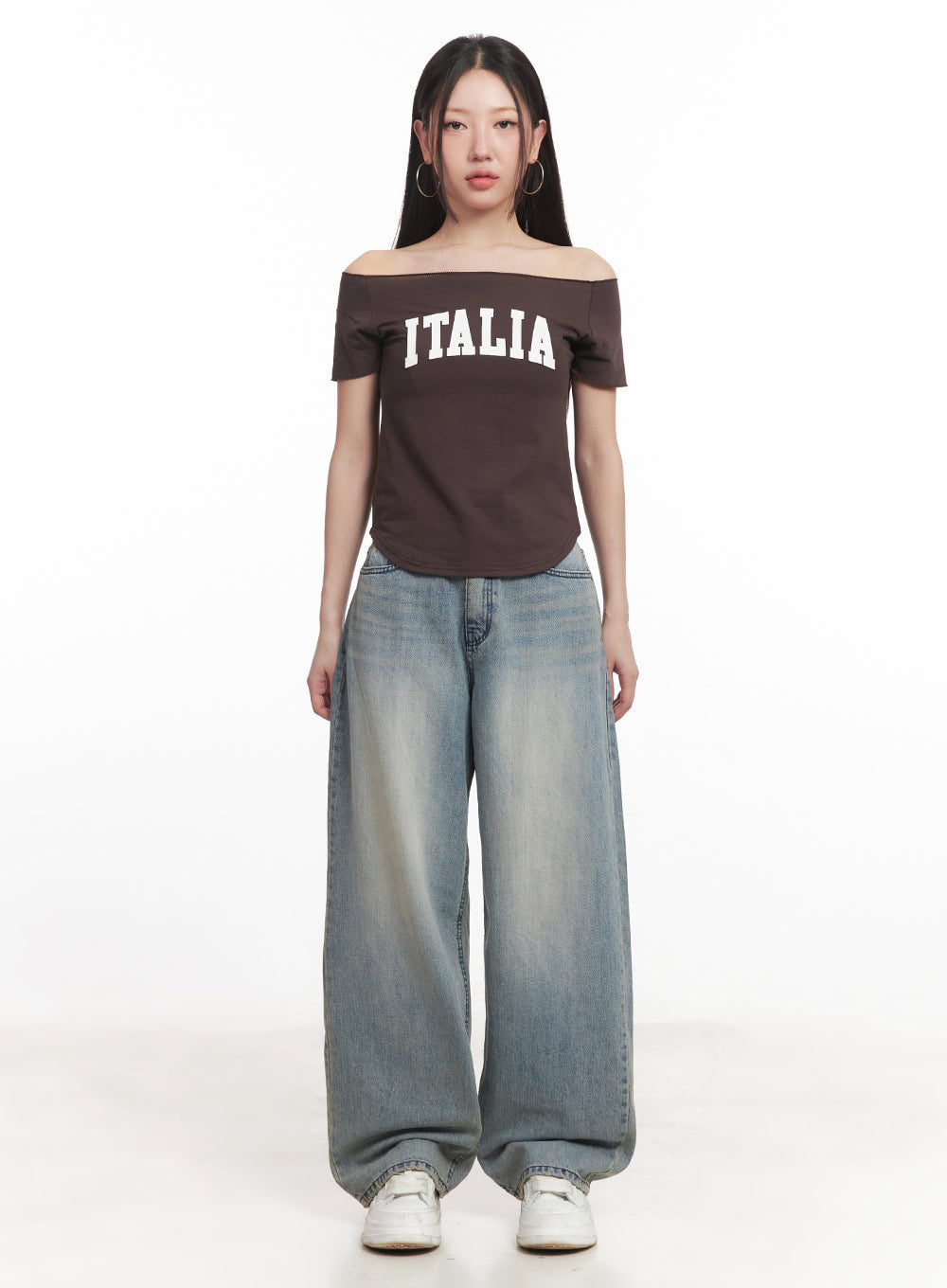 Casey Washed Baggy Jeans IM528 in light blue, front full-body on model, low-rise waistband with button fly, voluminous wide-fit leg with sun-faded wash, paired with brown off-shoulder top.
