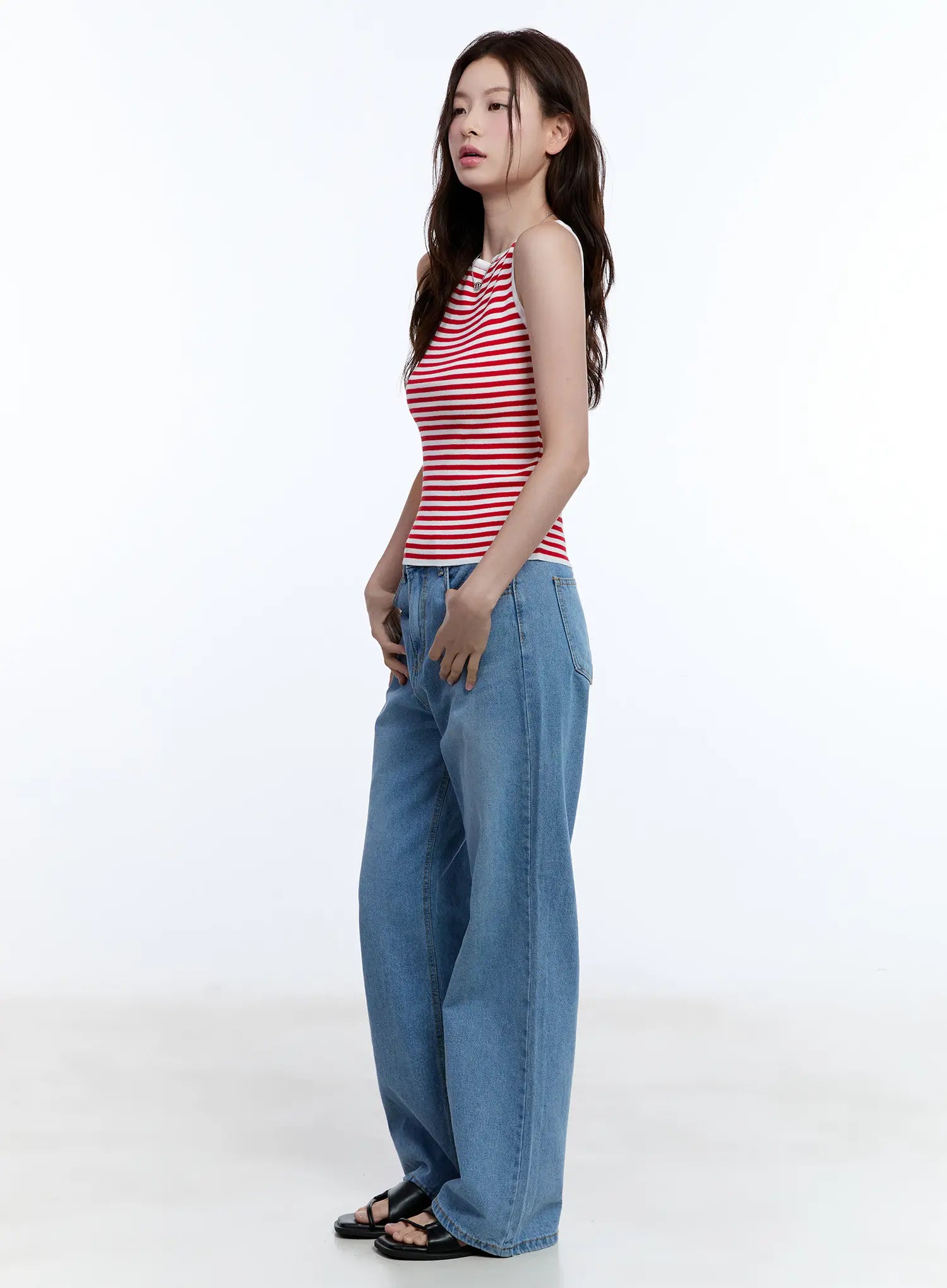 Jisoo Straight-Fit Jeans CU513 in blue, side-angle full-body shot on model, wide-fit washed denim showing straight leg silhouette, styled with red striped tank top.