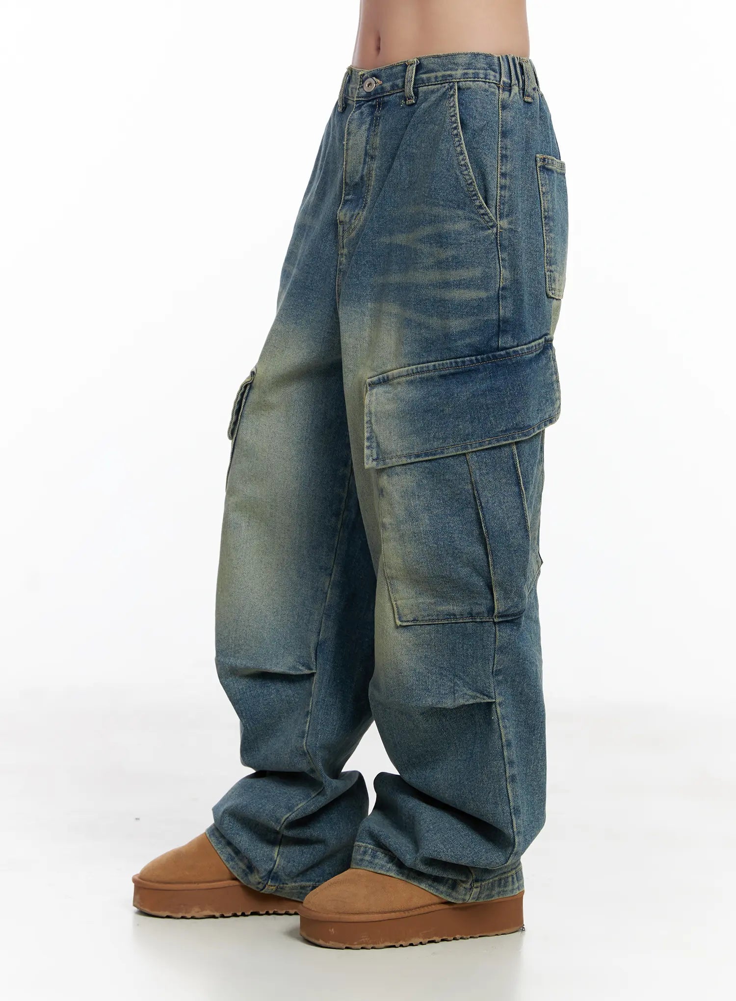 Jake Wide-Leg Cargo Jeans CJ515 in blue, side-view product shot on model, showing stacked cargo pockets, washed fade detail, and relaxed wide-leg length, paired with tan platform boots.