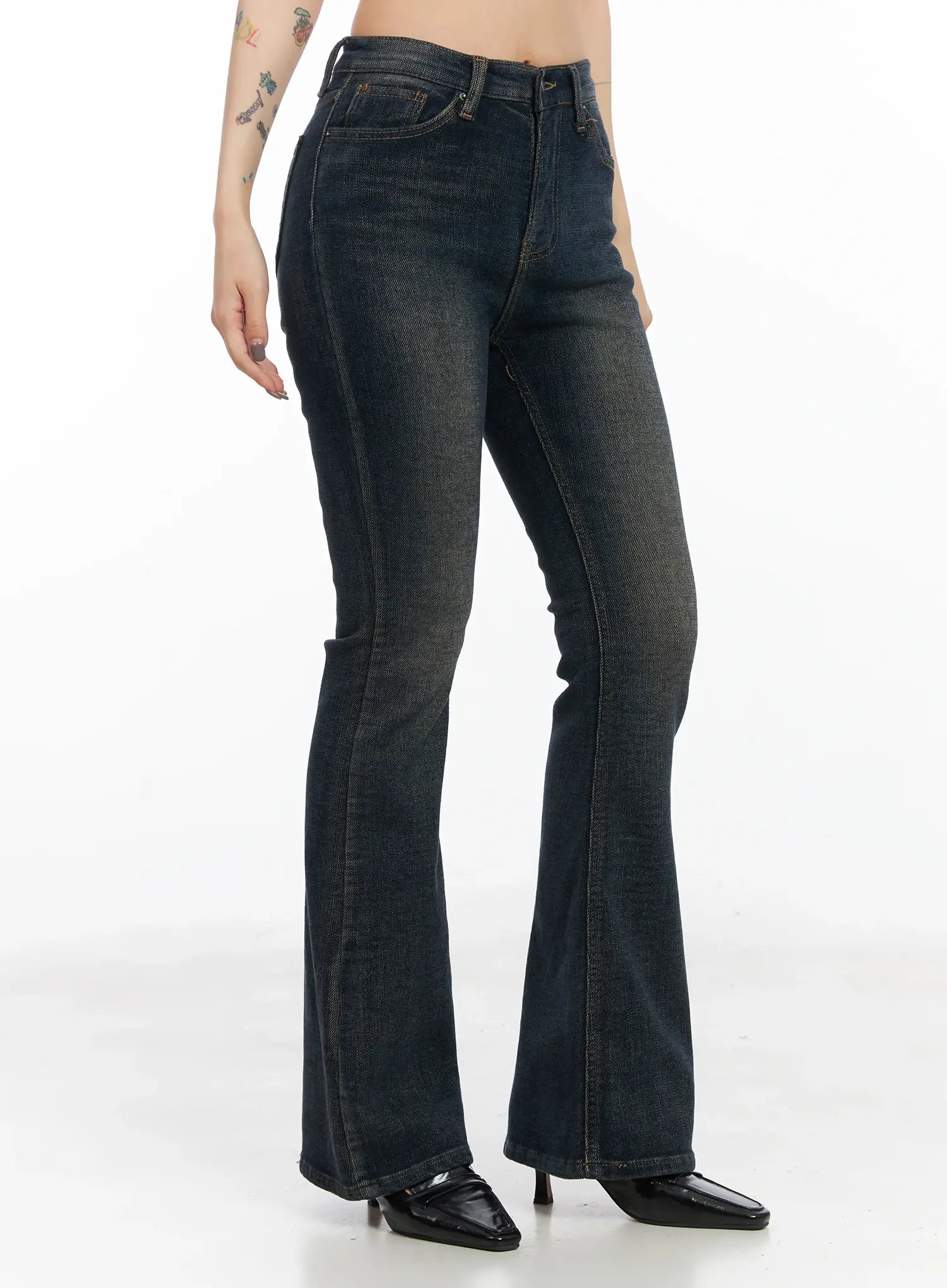 Jordyn High-Waist Bootcut Jeans CD502 in dark washed indigo, side view on model, slim high-waist through hip flaring to bootcut hem, washed cotton-blend denim, paired with black square-toe heels.