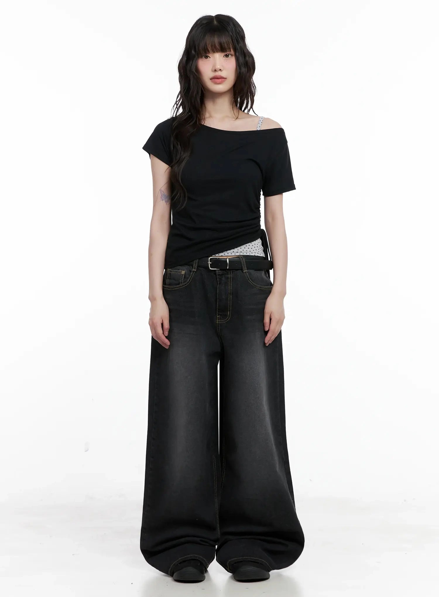 IU Vintage Black Baggy Jeans IL528 in black, full-body front shot on model, paired with black asymmetric crop top and belt, floor-grazing wide leg, acubi street style.