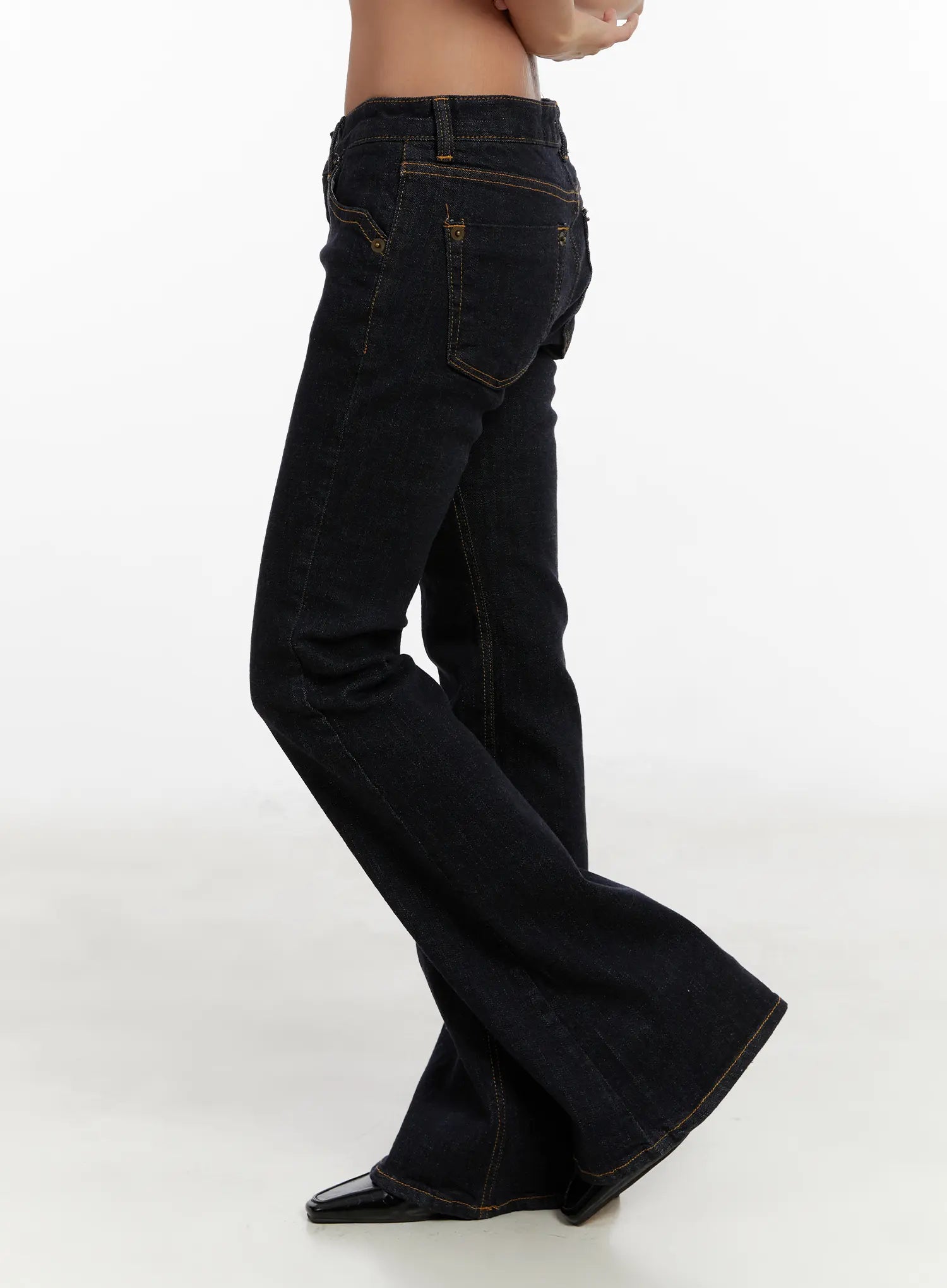Adalee Non-Fade Low-Rise Flare Jeans CD515 in dark indigo, side product shot on model, highlighting flare hem flare from knee, gold contrast topstitching, and side pocket detail.