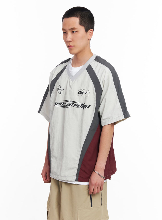 Men's Nylon Graphic V-Neck T-Shirt IU512 in light grey, three-quarter front angle on model, showing raglan sleeve seam and burgundy side panel, oversized fit, styled with khaki cargo pants.