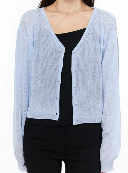 Sheer V-Neck Cardigan CU522 in light blue, close-up front torso shot on model, showing V-neck, button placket, and open loose knit texture over black cami top.