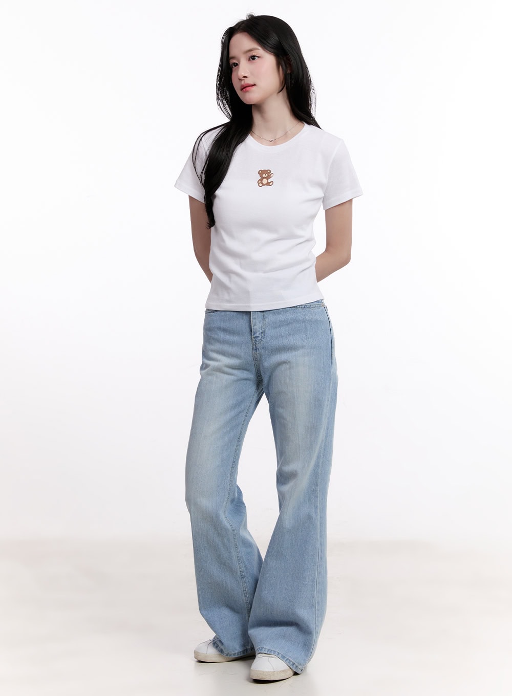 Daniella Relaxed-Fit Flared Jeans CM526 in light blue, three-quarter front angle on model, washed denim relaxed flare silhouette, styled with white crop tee and white sneakers.