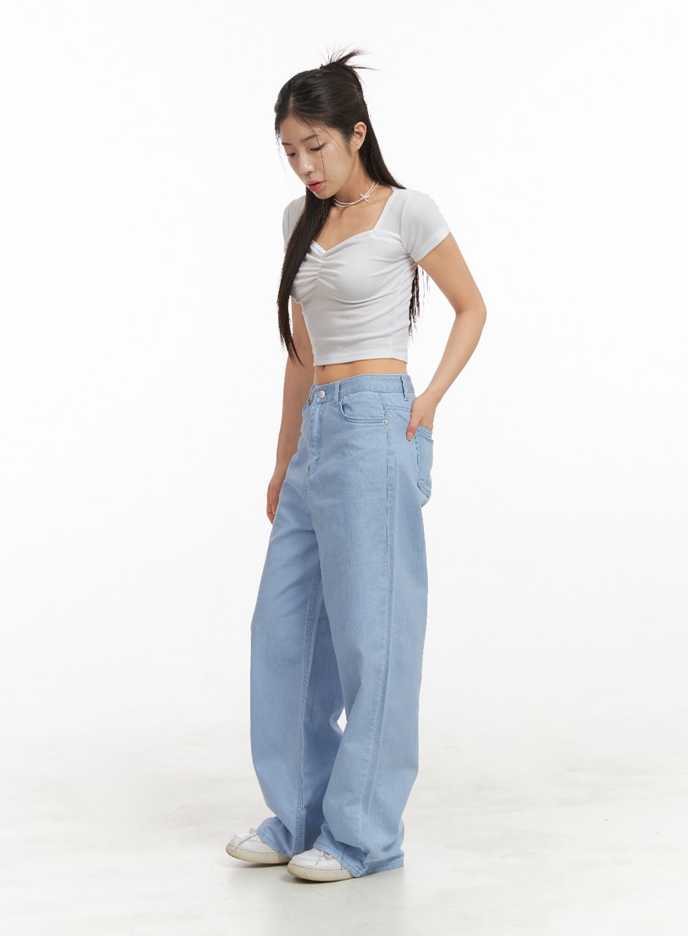 Solid Cotton Loose Fit Straight Jeans OA429 in light blue, side angle full-length shot on model looking down, loose wide-leg silhouette pooling at hem, paired with white crop top.