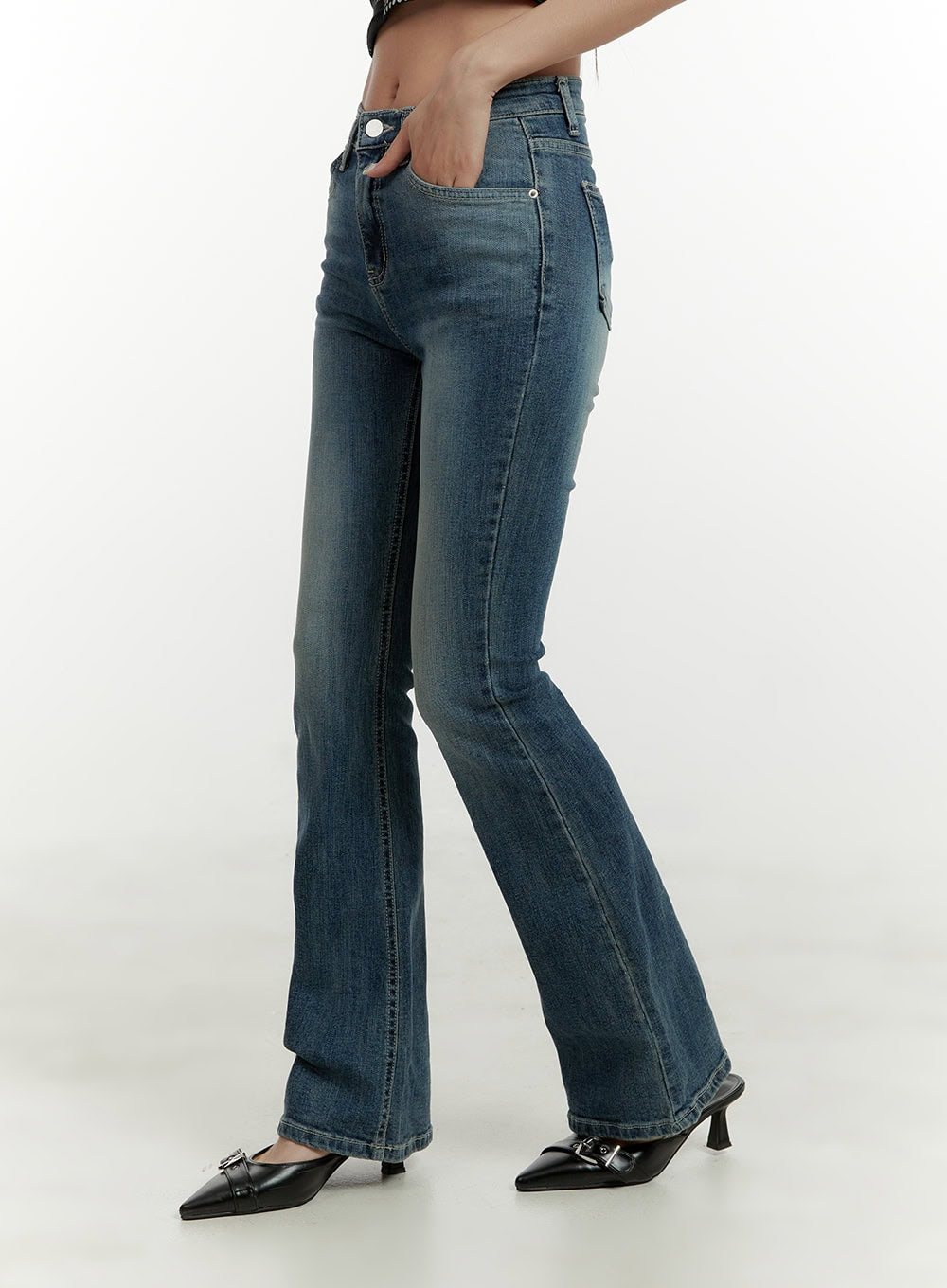 Low Rise Bootcut Jeans CY409 in blue, side view on model, slim fit through hip with gentle bootcut flare, washed denim, hand in pocket pose.