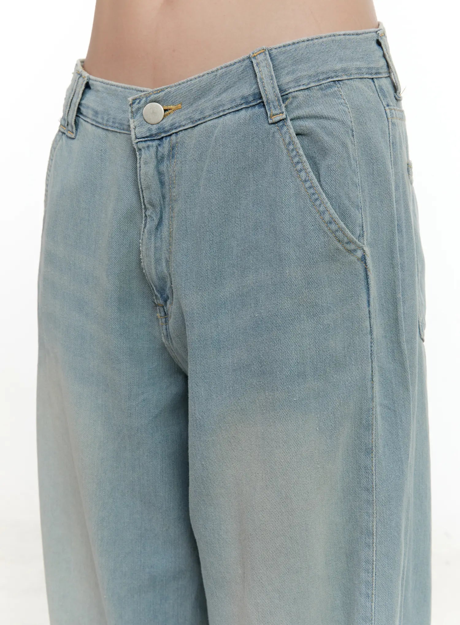 Huening Wide-Leg Jeans CL531 in blue, close-up detail of waistband and front pockets, showing V-notch low-rise waist, gold button, and washed denim texture on model.