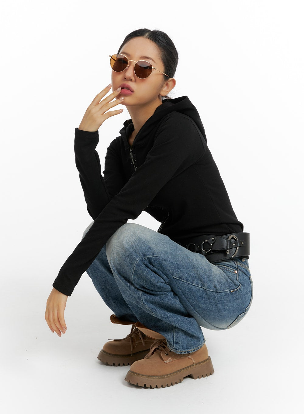 Wide Washed Denim Jeans CF419 in blue, crouching pose on model, wide-leg washed denim with street styling, paired with black hoodie, belt bag, and tan boots.