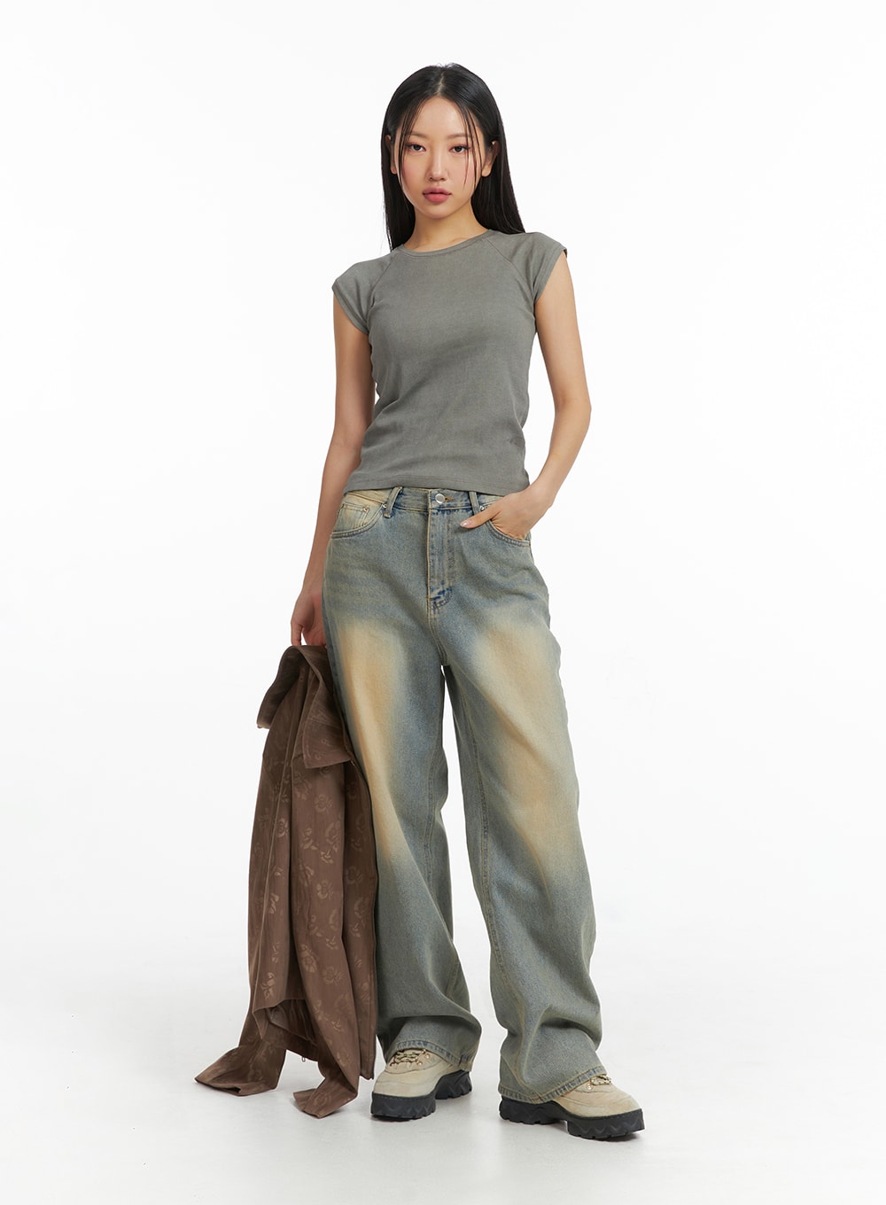 Dark Wash Jeans CF303 in blue, full-body front shot on model, wide-leg washed denim with amber fade, styled with grey sleeveless top and brown jacket held at side.
