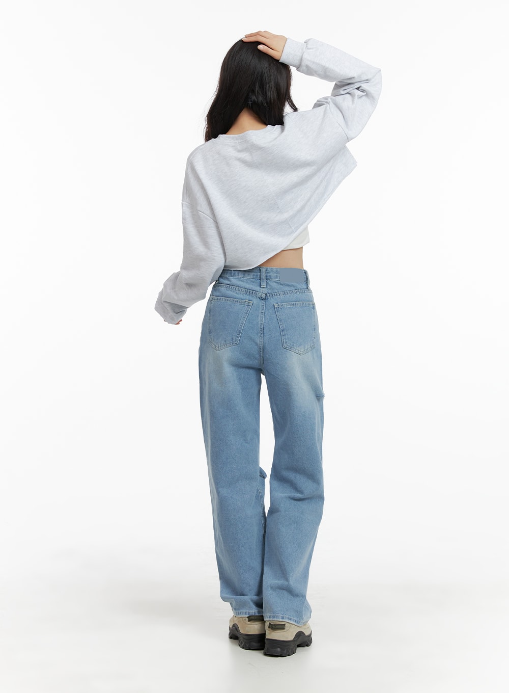 Cut Out Washed Straight Jeans OM421 in blue, back full-length on model with hand raised, clean back view showing straight leg fall, washed blue cotton denim, styled with grey crop top.