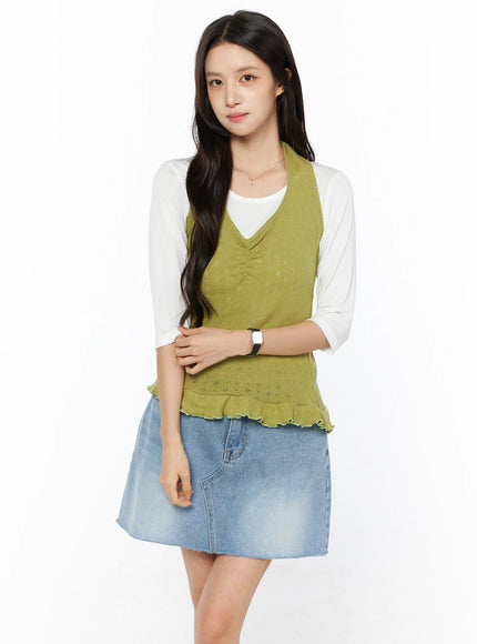 Frill Hem Halter Neck Top CU522 in green, front view on model with relaxed arms, halter neckline and pointelle knit detail visible, ruffled hem, layered over white top and light blue denim mini skirt.