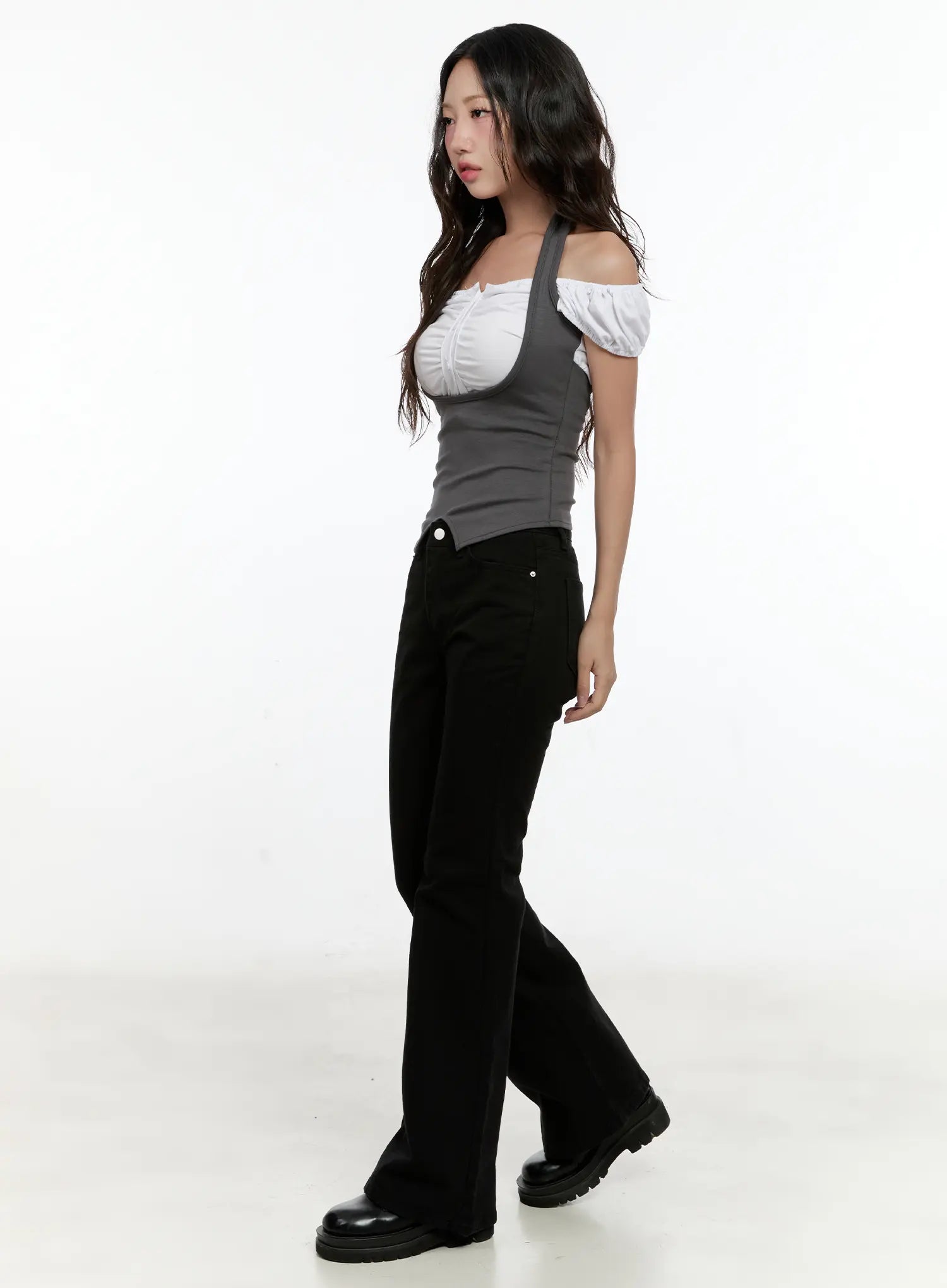 Classic Flare Pants CL531 in black, side full-body shot on model, flare leg line visible, paired with layered off-shoulder white top and black loafers.