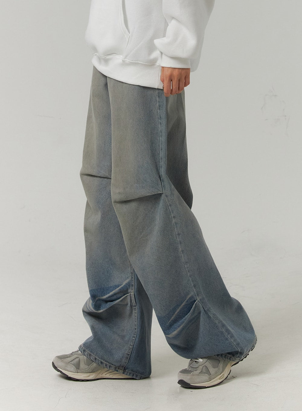 Pintuck Washed Denim Wide-Leg Jeans CJ418 in blue, waist-to-hem side close-up on model, pintuck knee seam and wide denim leg clearly visible, gradient grey-to-blue wash, worn with white hoodie.