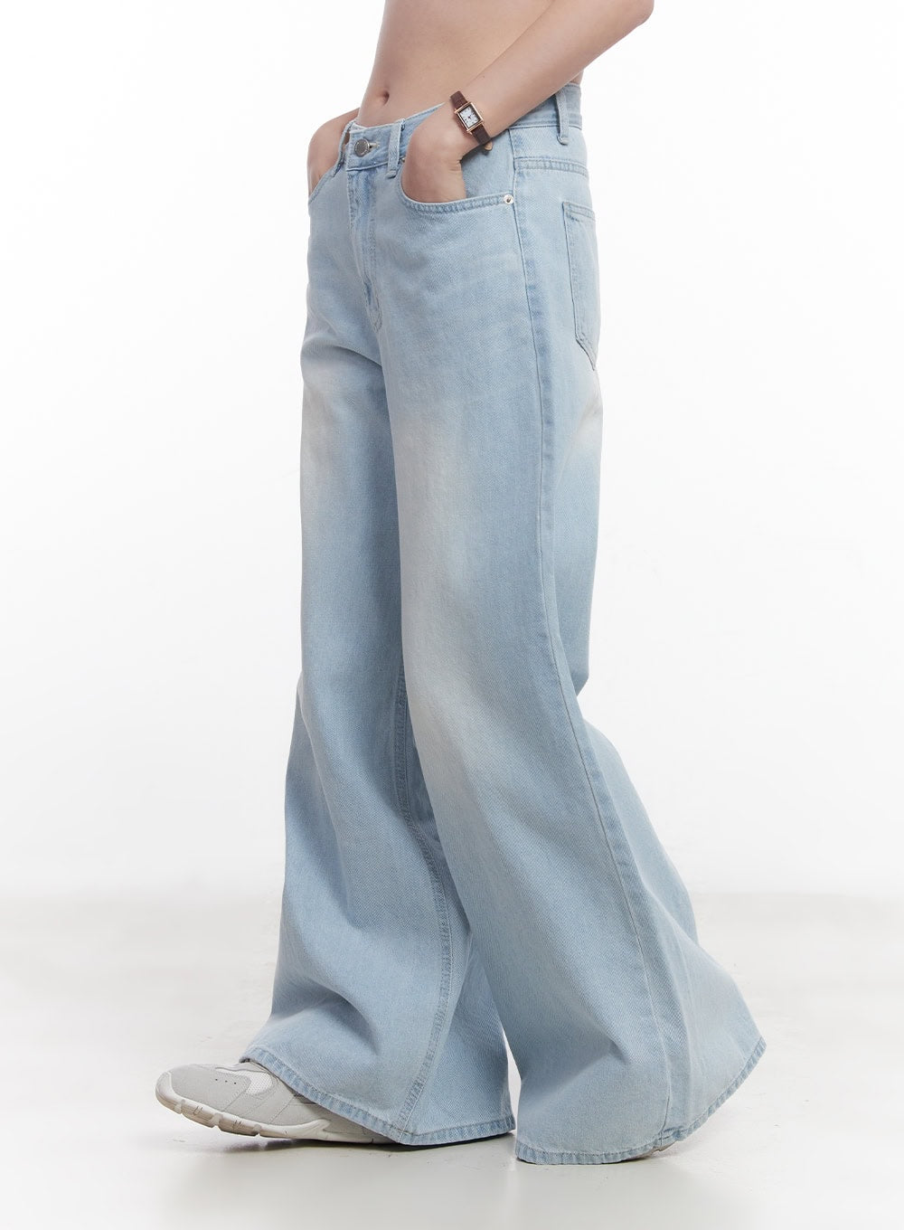 Judie Washed Wide-Leg Jeans CY519 in light blue, side close-up on model, showing washed denim texture, wide flared leg, hip pocket detail, and floor-length hem over white sneakers.
