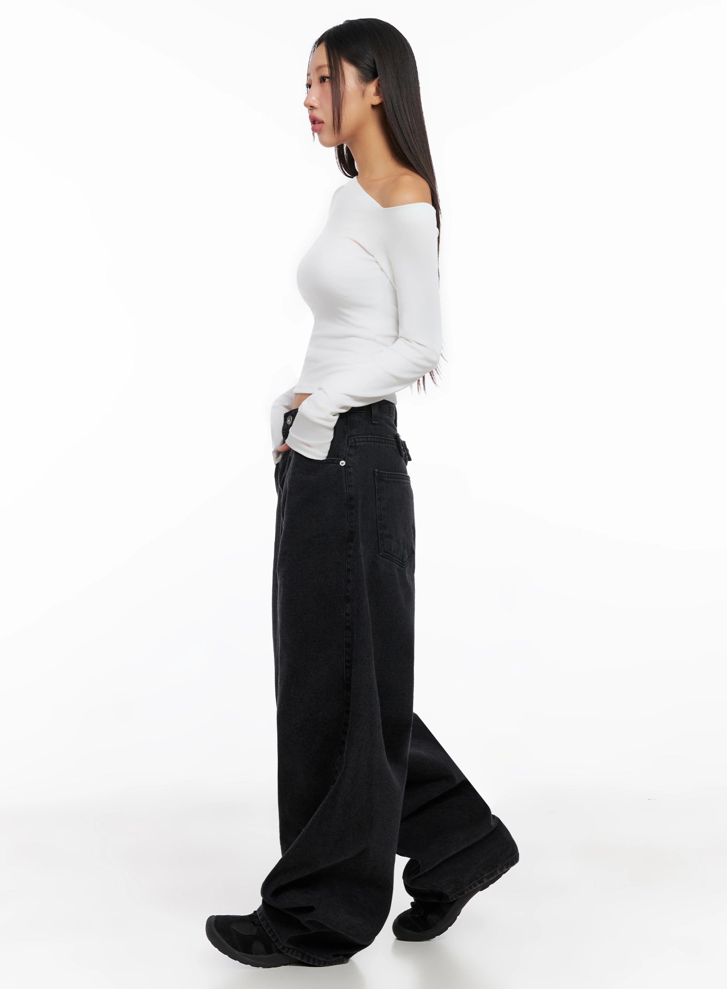 Sunwoo Embroidered Wide Leg Jeans IG528 in black, side view on model, showing exaggerated wide-leg volume and long length pooling at floor, paired with white asymmetric crop top and black boots.