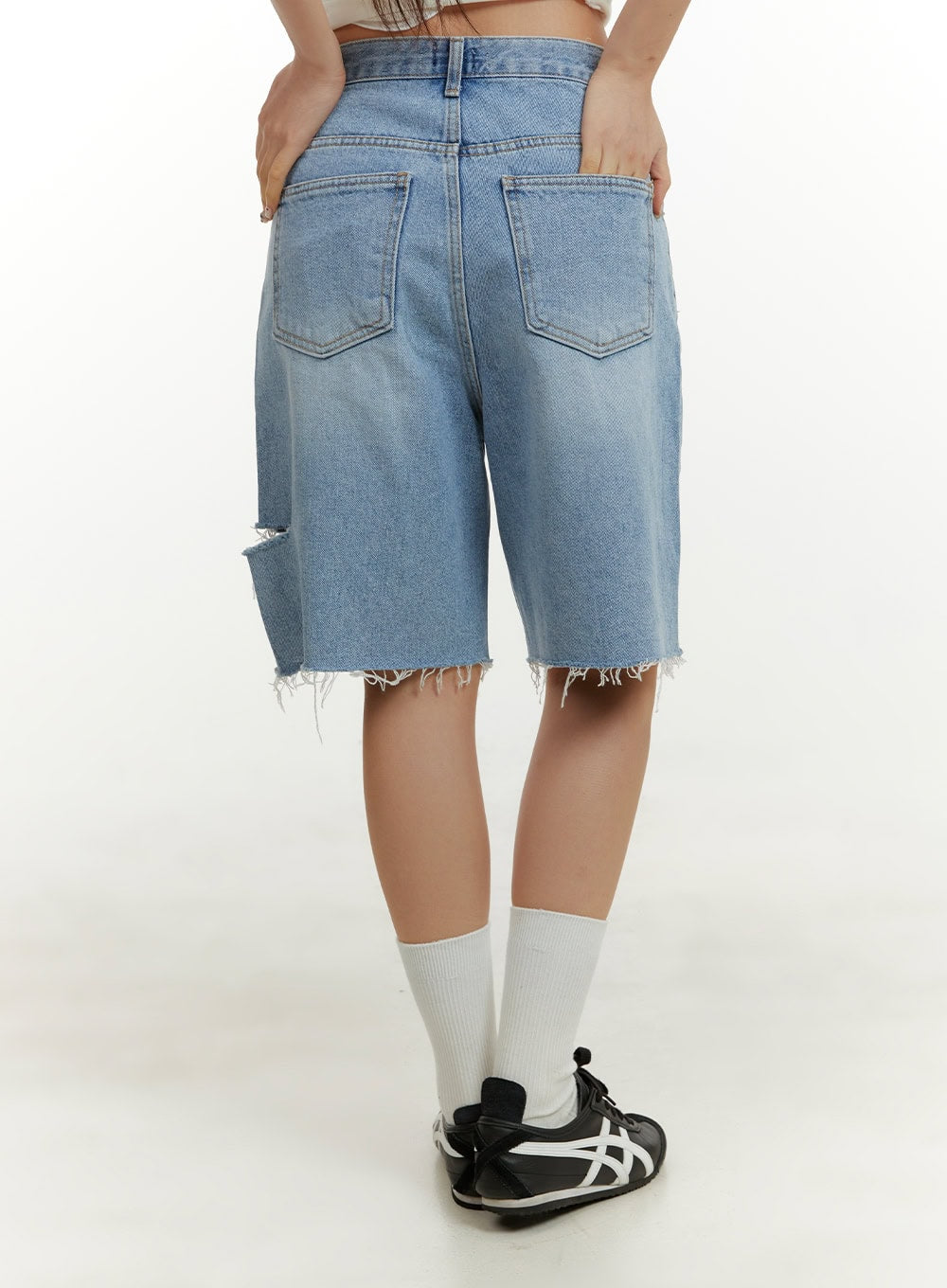 Straight Leg Jorts CY408 in blue, back view on model, showing dual back pockets, ripped detail on left leg, frayed raw hem, washed denim finish, styled with white socks and sneakers.