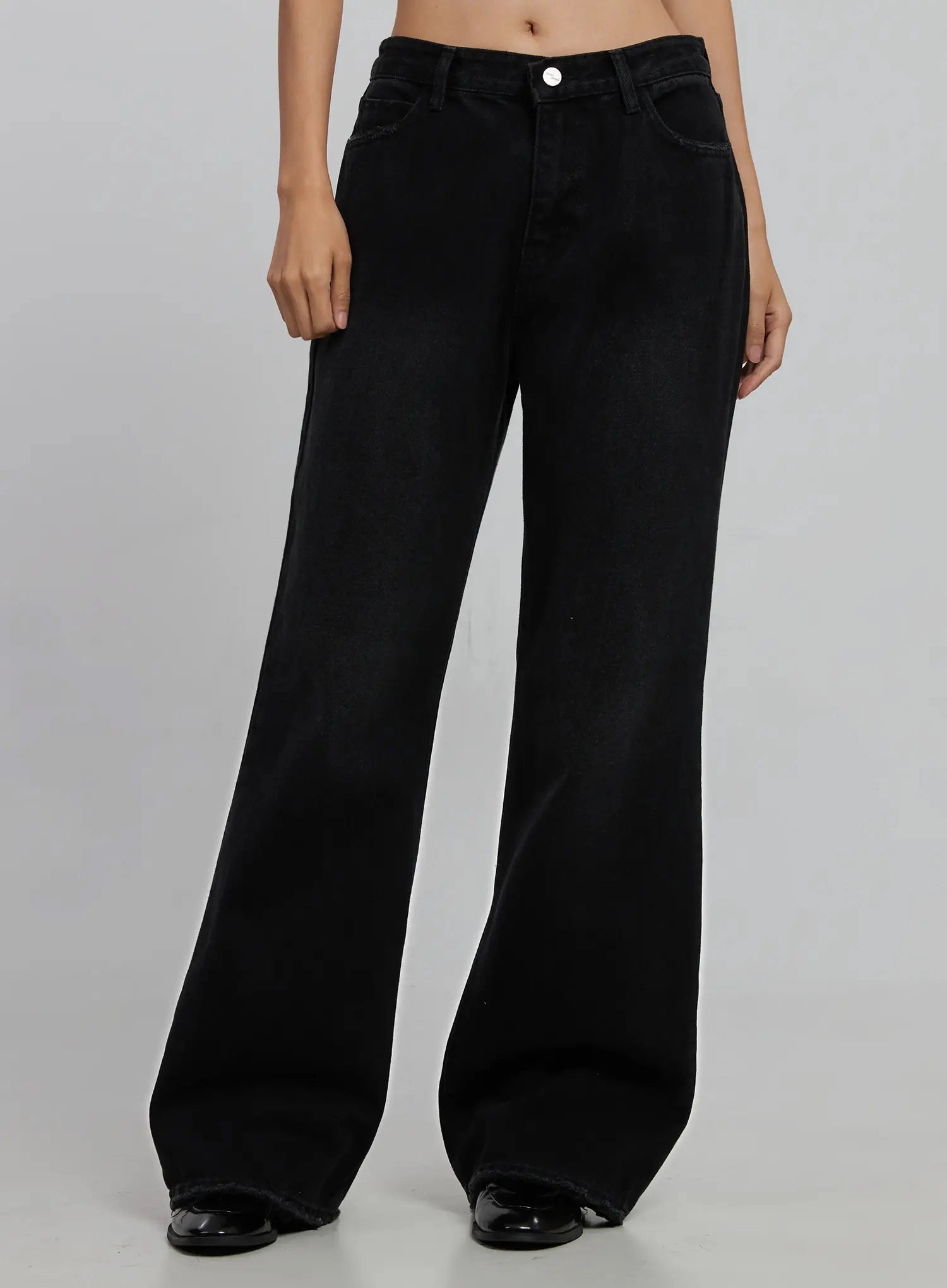 Imani Wide-Leg Flared Jeans ID516 in black, front product view on model (waist to toe), solid black cotton wide-leg flare, slightly darker wash than index 0, front pockets, worn with black loafers.