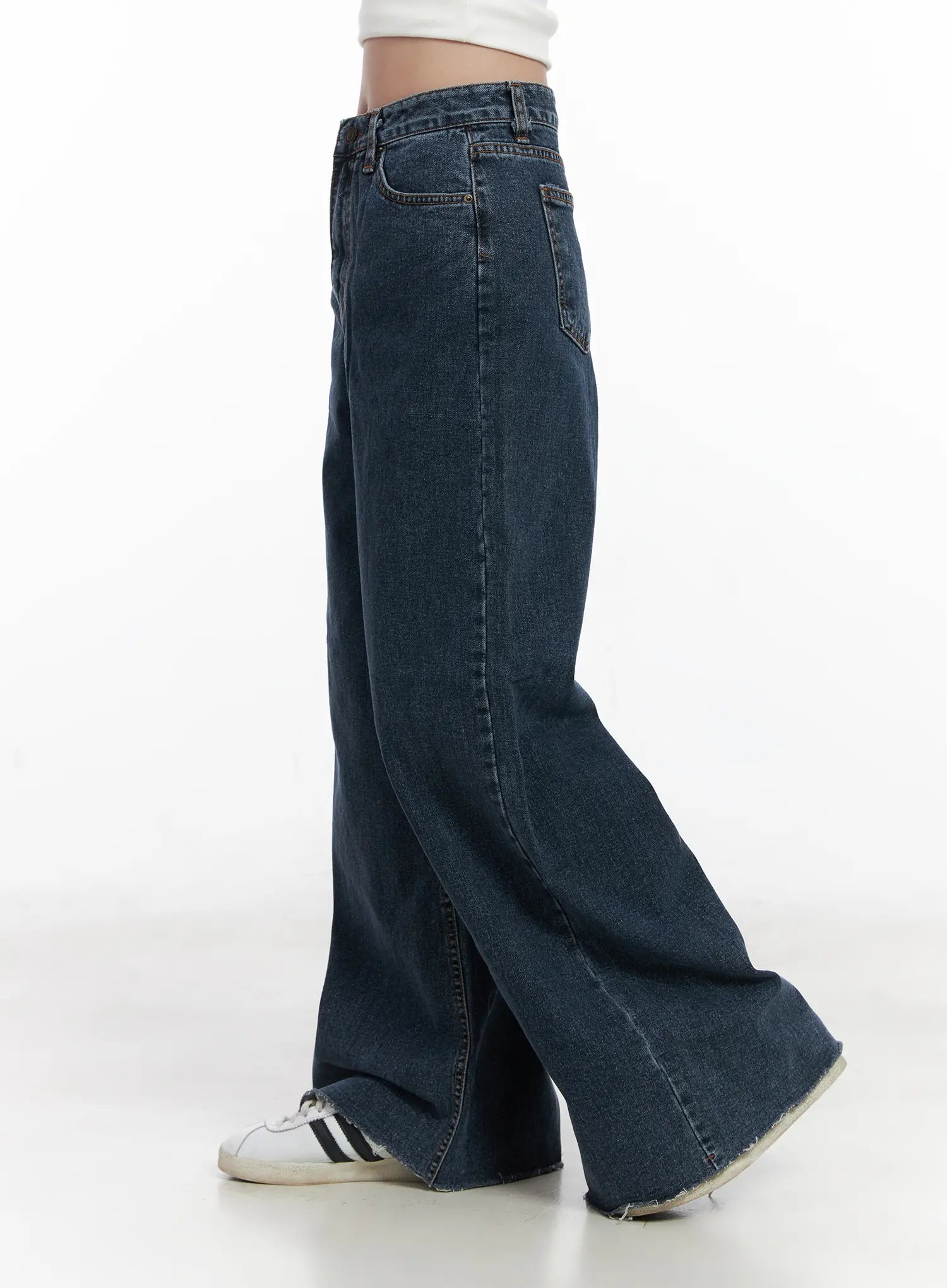 Louisa Ultra Wide Flared Jeans CN527 in dark blue, side close-up from waist to hem, highlighting ultra wide flared leg silhouette, side seam stitching, and raw frayed hem pooling over white sneaker.