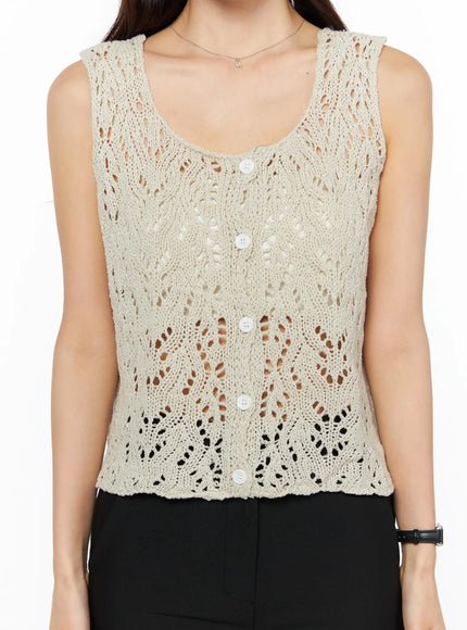 Crochet Knit Sleeveless Top CU522 in beige, close-up front torso shot on model, leaf-pattern open-knit crochet fabric and white button front clearly visible, cropped hem.