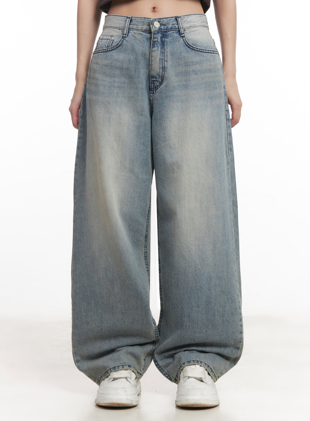 Casey Washed Baggy Jeans IM528 in light blue, front waist-to-hem close-up on model, five-pocket construction, washed denim with whisker fading, extreme wide-leg hem bunching over white sneakers.