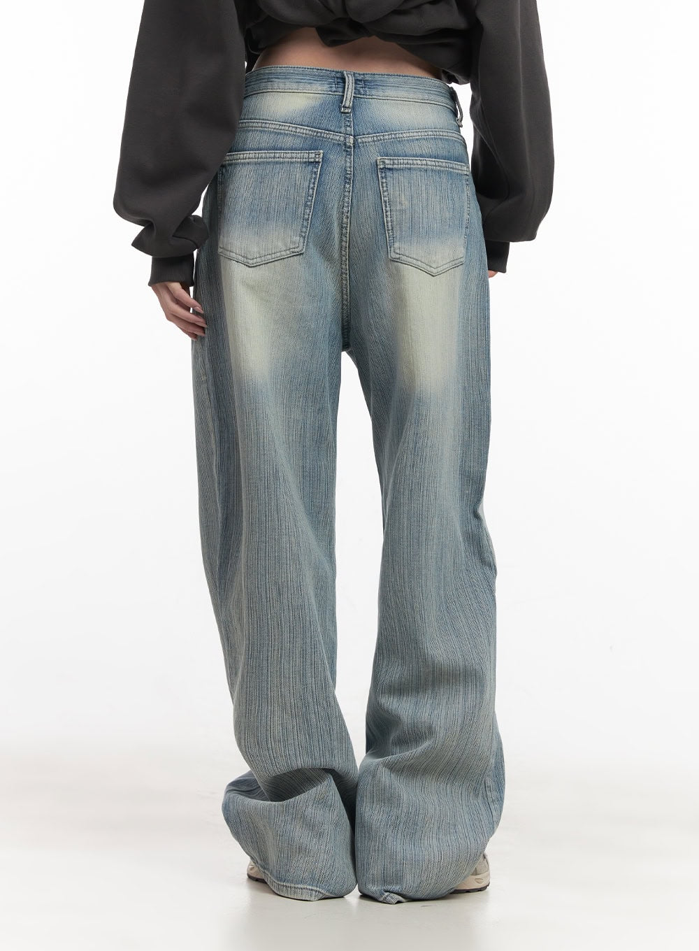 Nicola Washed Wide-Leg Jeans CF514 in light blue, back close-up on model, showing dual back pockets with V-stitch detail and faded wash across seat and legs.