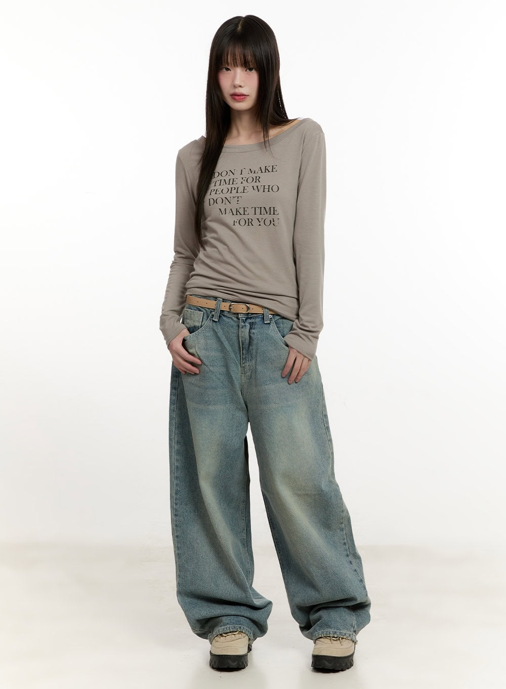 Galinda Washed Baggy Jeans CM513 in vintage blue, full-body front on model, styled with beige graphic long-sleeve top and tan belt, street acubi look with chunky sneakers.