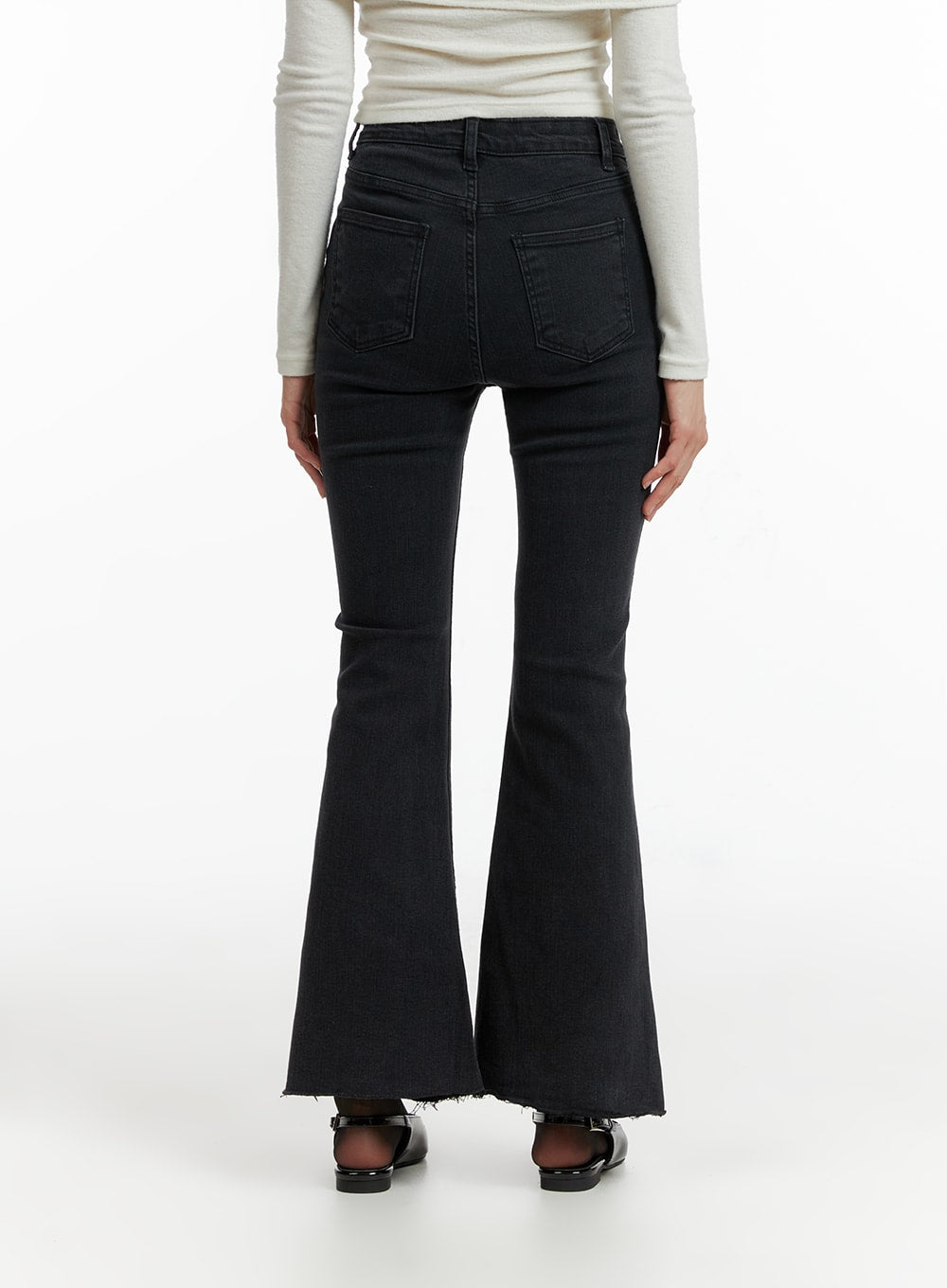 Mid Waist Button Flared Jeans IF402 in dark grey, back full-length shot on model, dual back pockets, slim fit through seat tapering into wide flare, raw frayed hem, with white long-sleeve top.