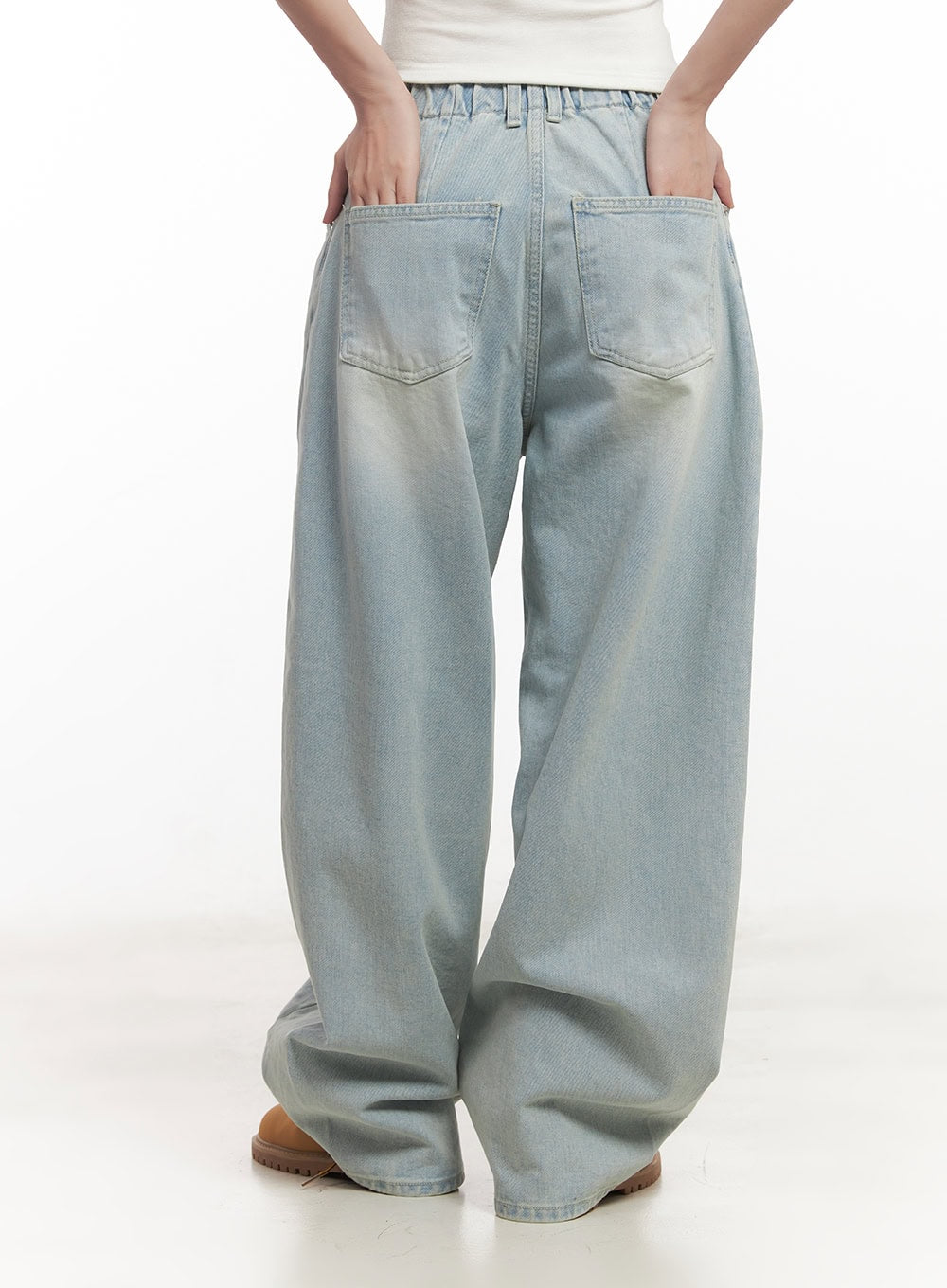 Alia Washed Wide-Leg Jeans CA518 in light blue, straight back view on model, showing dual back patch pockets, elastic waistband detail, and light sun-faded wash across wide-leg cut.