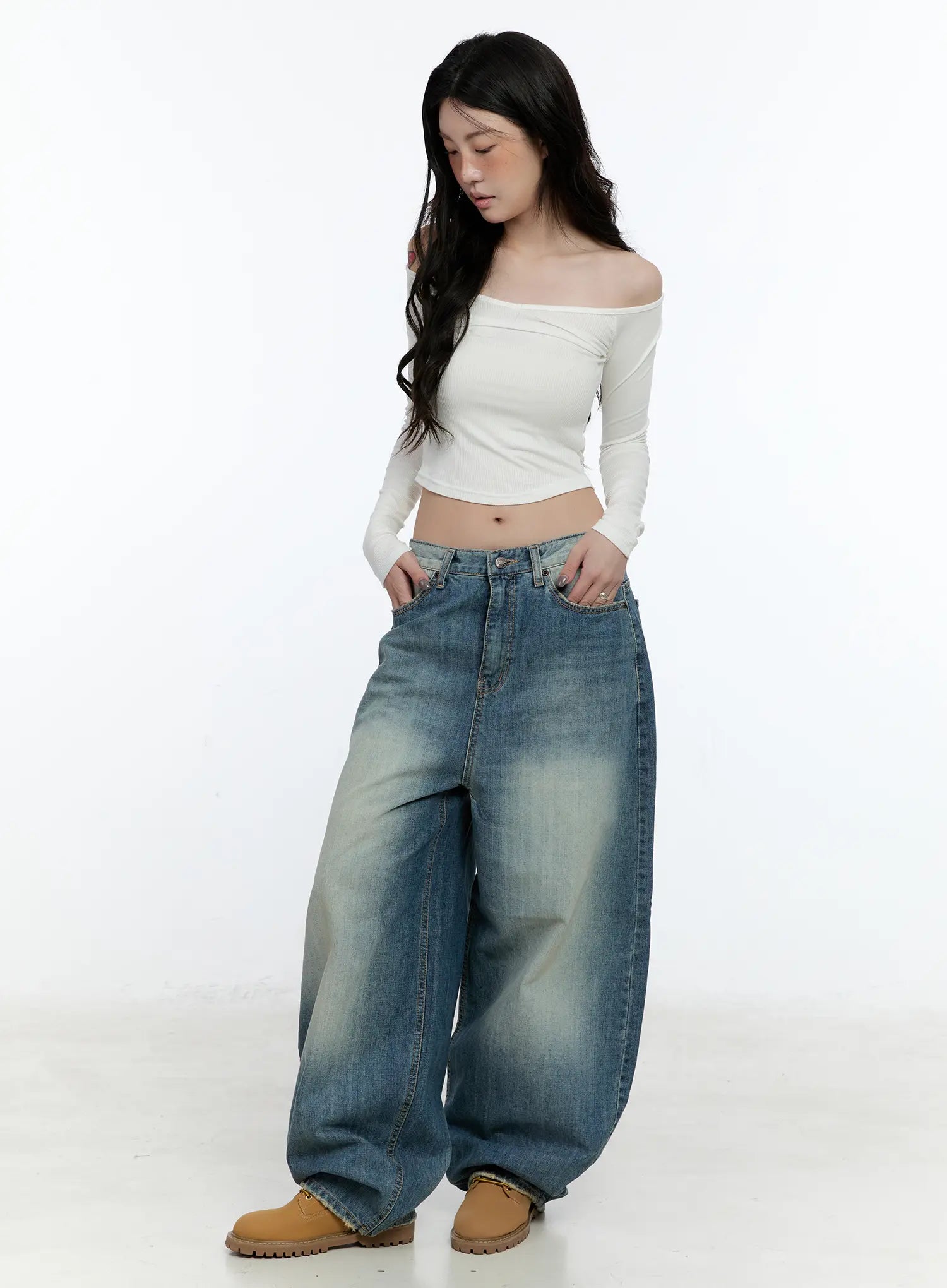 Jiso Baggy Wide Jeans CN517 in blue, front full-body shot on female model, washed baggy wide leg with mid-rise waist, paired with white off-shoulder crop top and tan boots.