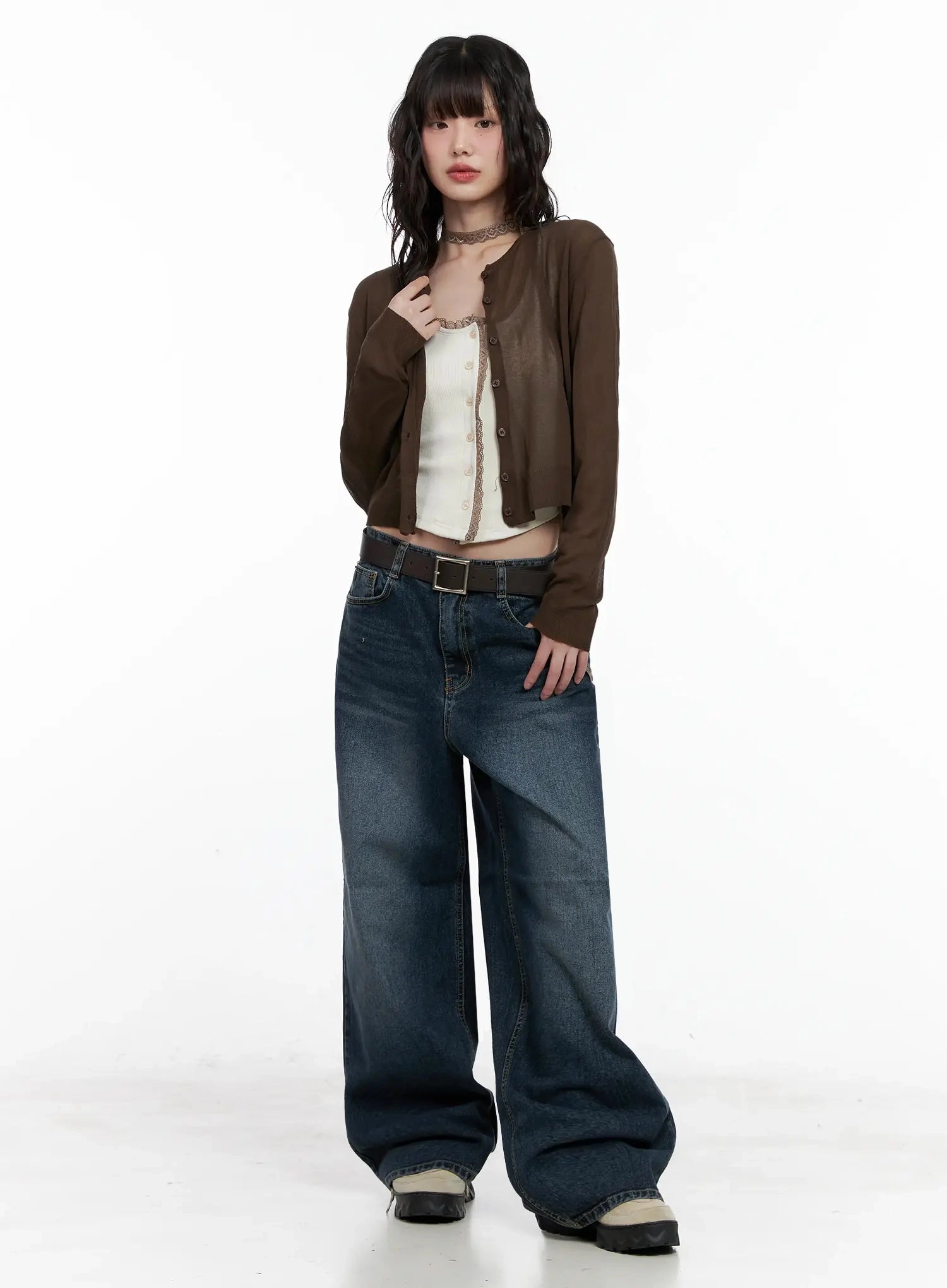 Mashiro Vintage-Wash Wide Jeans IL531 in dark blue, three-quarter front view on model with hand raised, wide-leg washed denim with leather belt, layered with brown cropped cardigan and white cami.