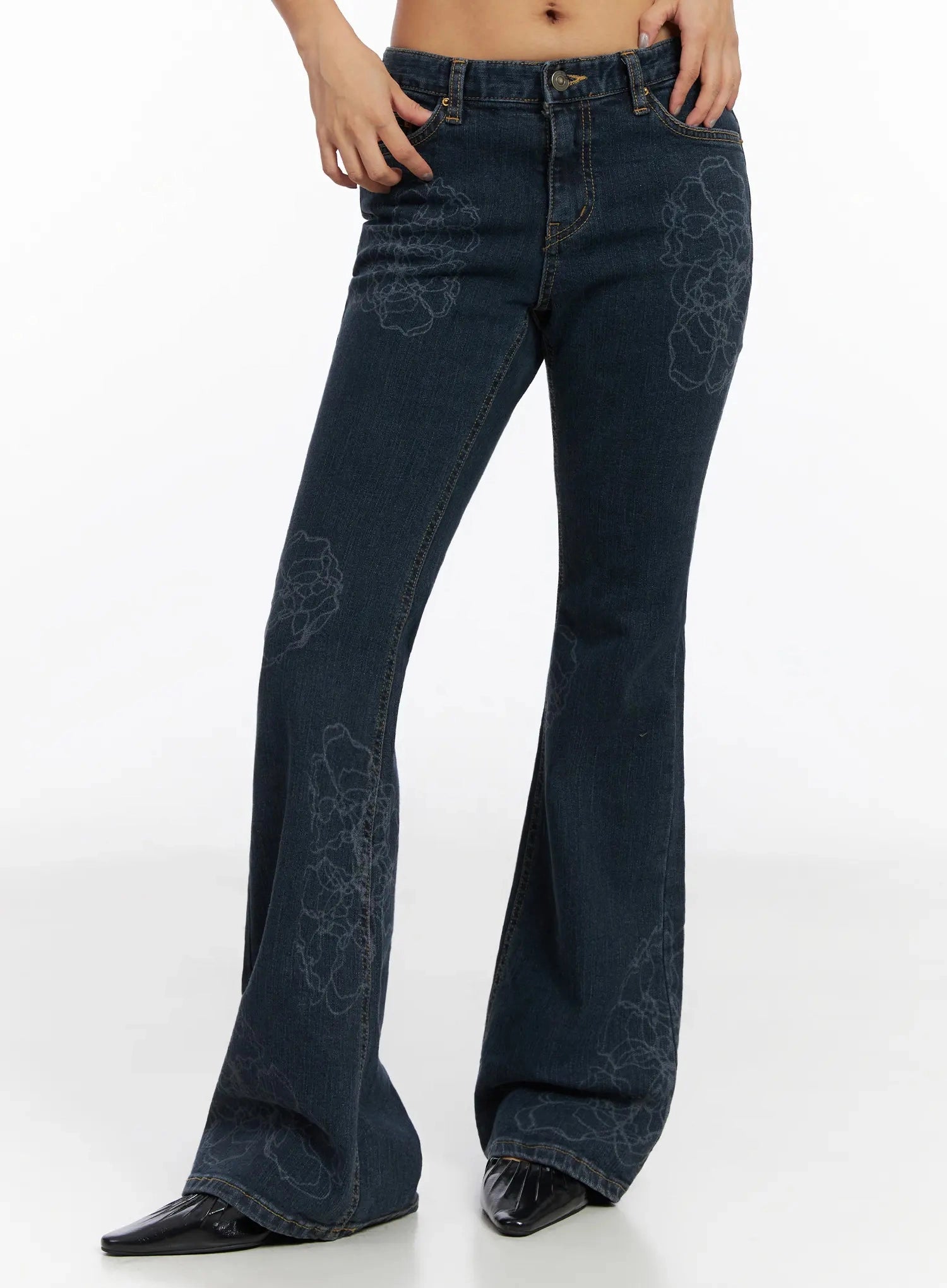 Amari Floral Embriodered Bootcut Jeans IN528 in dark blue, cropped front shot from waist to hem on model, floral stitch detail across thigh and flare leg, low-rise fit, gold hardware, black pointed boots.