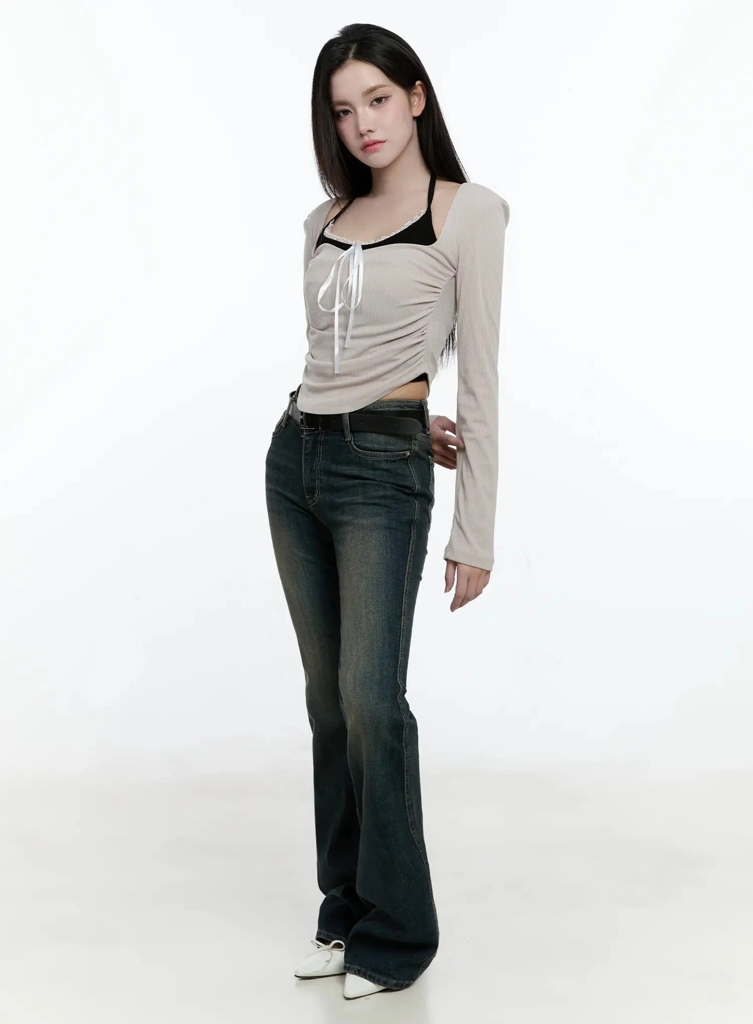 Karla Vintage Logo Hip Pad Flare Jeans IO520 in washed dark blue, three-quarter side front on model, long flare leg with vintage wash, styled with beige crop top and white flats.