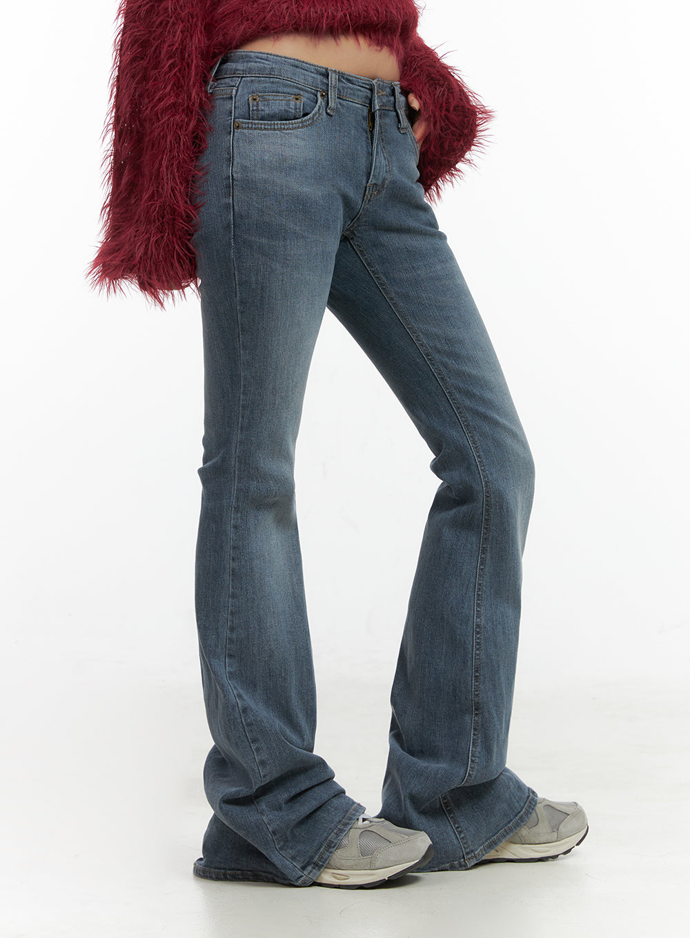 Liv Washed Denim Low Waist Bootcut Jeans CO414 in blue, side close-up on model, low waist waistband and slim thigh to bootcut flare detail, washed denim texture, paired with red fuzzy top.