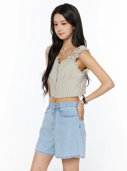Plaid Ruffle Sleeveless Top CU522 in beige, side view on model, ruffle-edged straps and cropped silhouette visible, paired with light blue denim shorts, clean studio background.