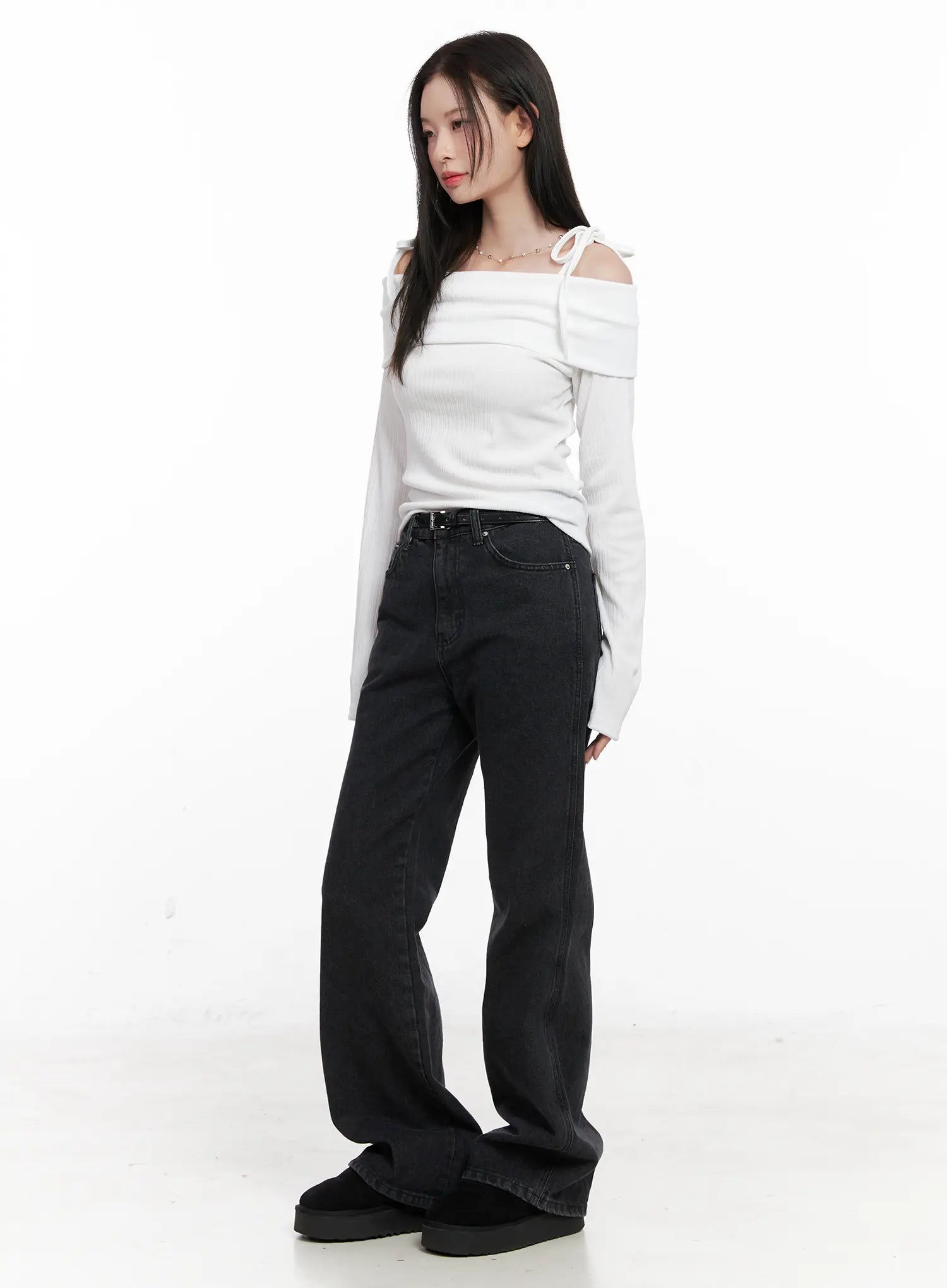 Eileen Belted Flare Jeans CN504 in washed black, three-quarter side view on model, full-length flare leg and leather belt detail, styled with white off-shoulder ribbed top.