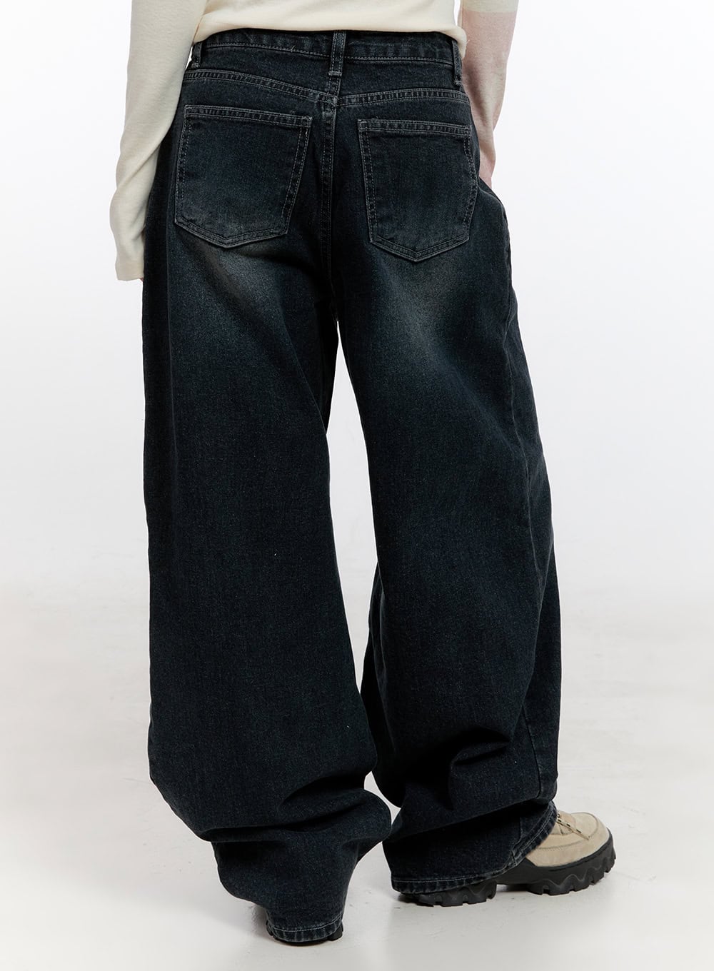 Camila Washed Cotton Jeans CN422 in dark blue, back product shot on model, wide baggy washed denim showing dual back pockets with stitching, washed fading detail, chunky sneakers.