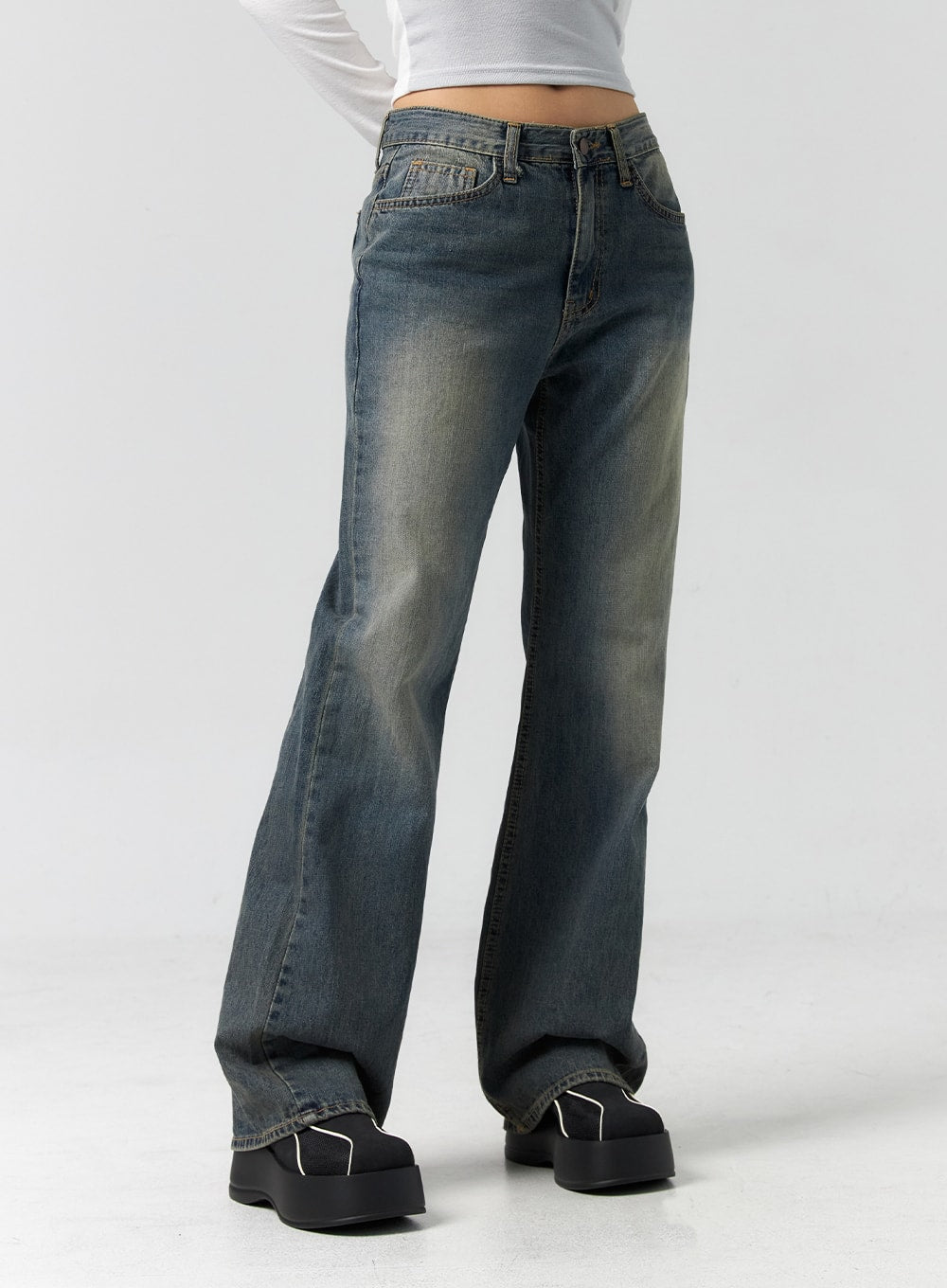 Vintage Wash Bootcut Jeans CS305 in blue, angled front close-up from waist to hem on model, showing front pockets, faded wash detail, and gentle bootcut leg opening.