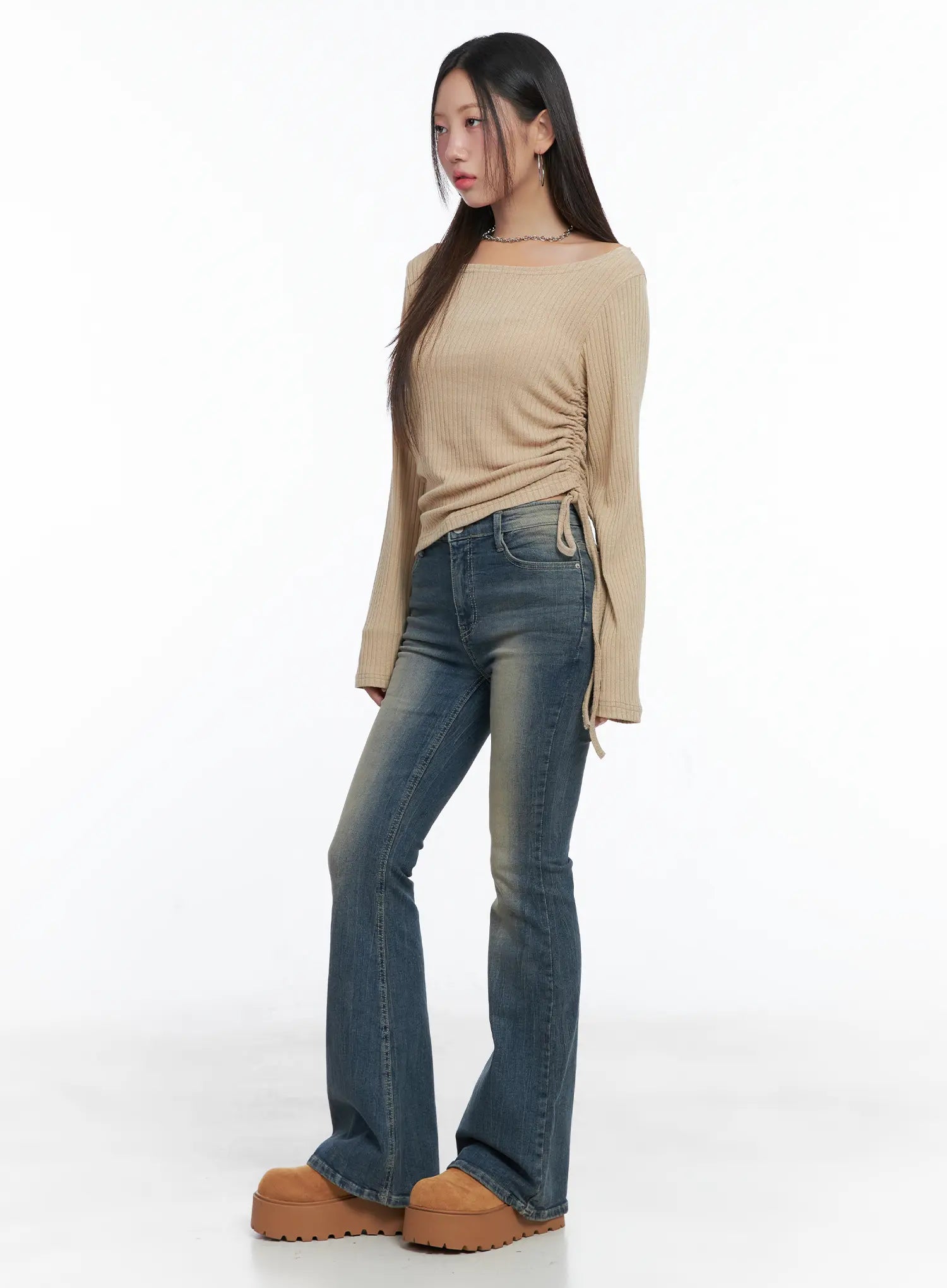 Sloan Vintage Hip Pad Flare Jeans CS502 in dark blue, three-quarter side outfit shot, model in beige ribbed top, flare silhouette elongating the leg, washed cotton-spandex blend.
